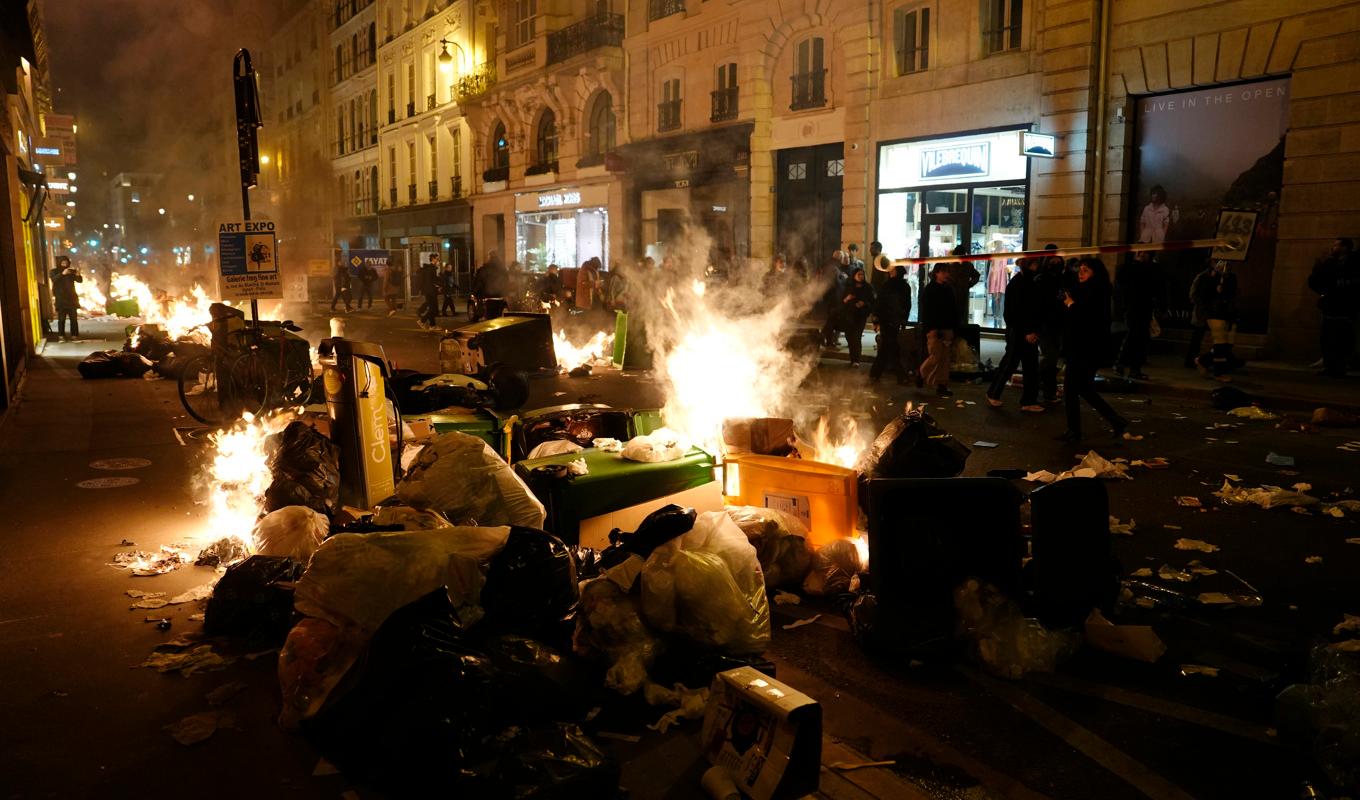 Sopor brinner i centrala Paris efter att demonstranter tänt eld på dem. Foto: Lewis Joly/AP/TT