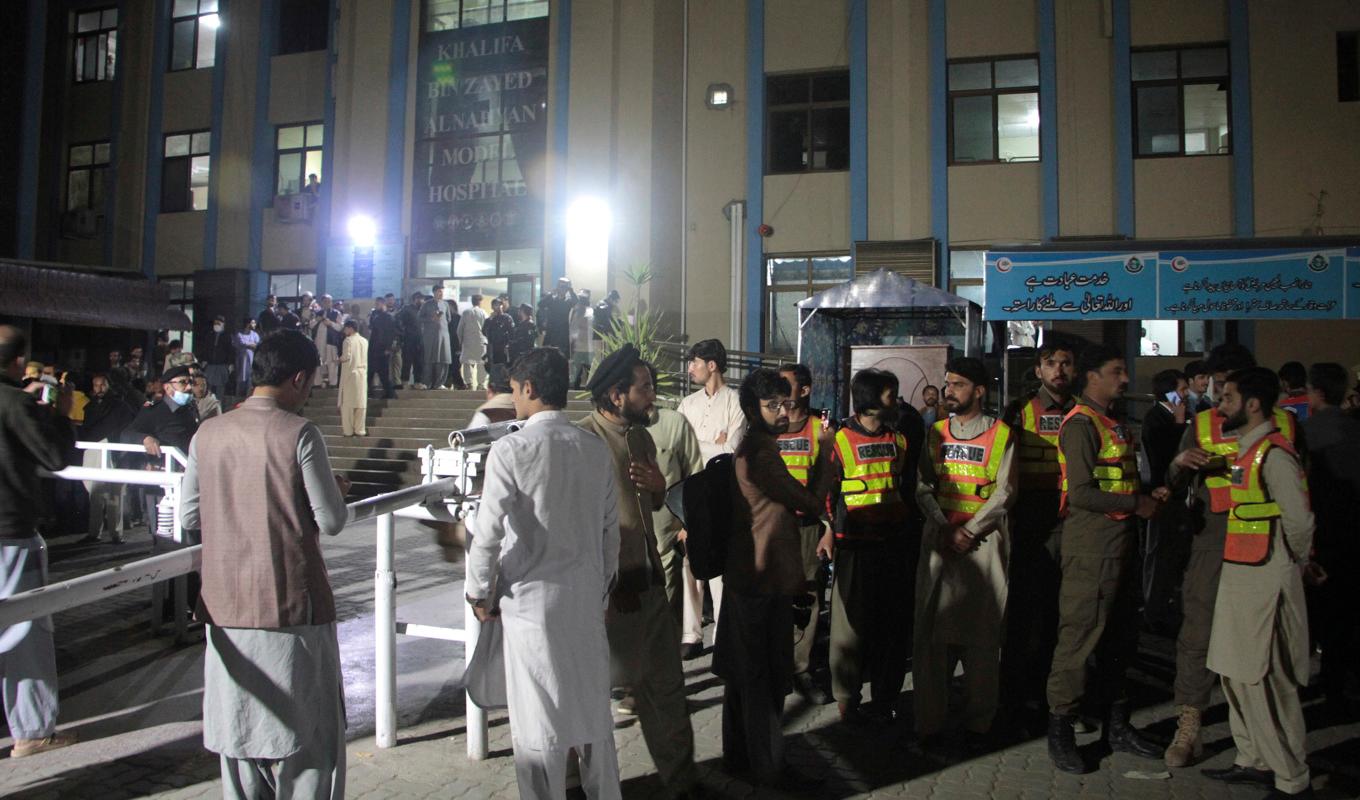 Räddningsarbetare och andra människor samlas utanför ett sjukhus i Pakistan. Foto: Naveed Ali/AP/TT