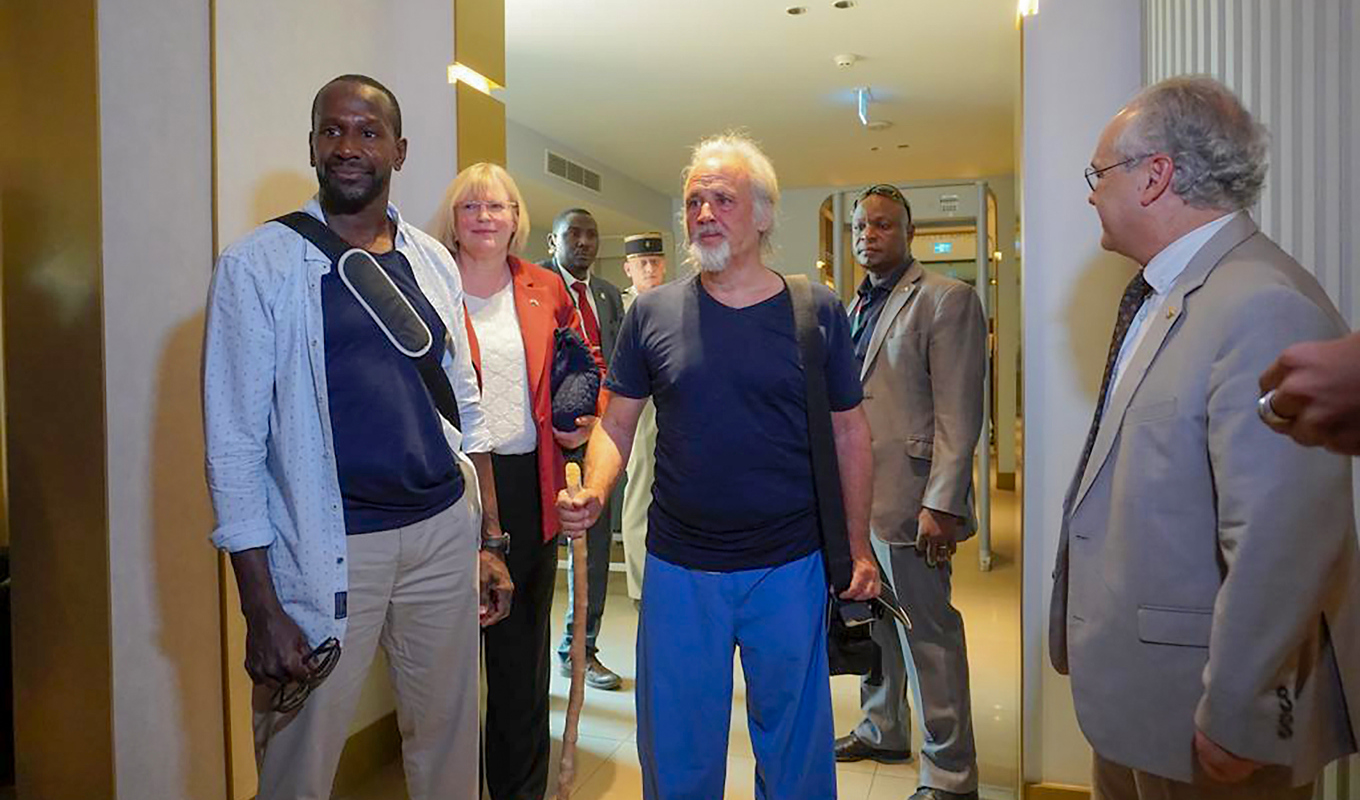 Olivier Dubois, till vänster, och Jeffery Woodke i mitten, vid flygplatsen i Niamey. Foto: Judith Besnard/AP/TT
