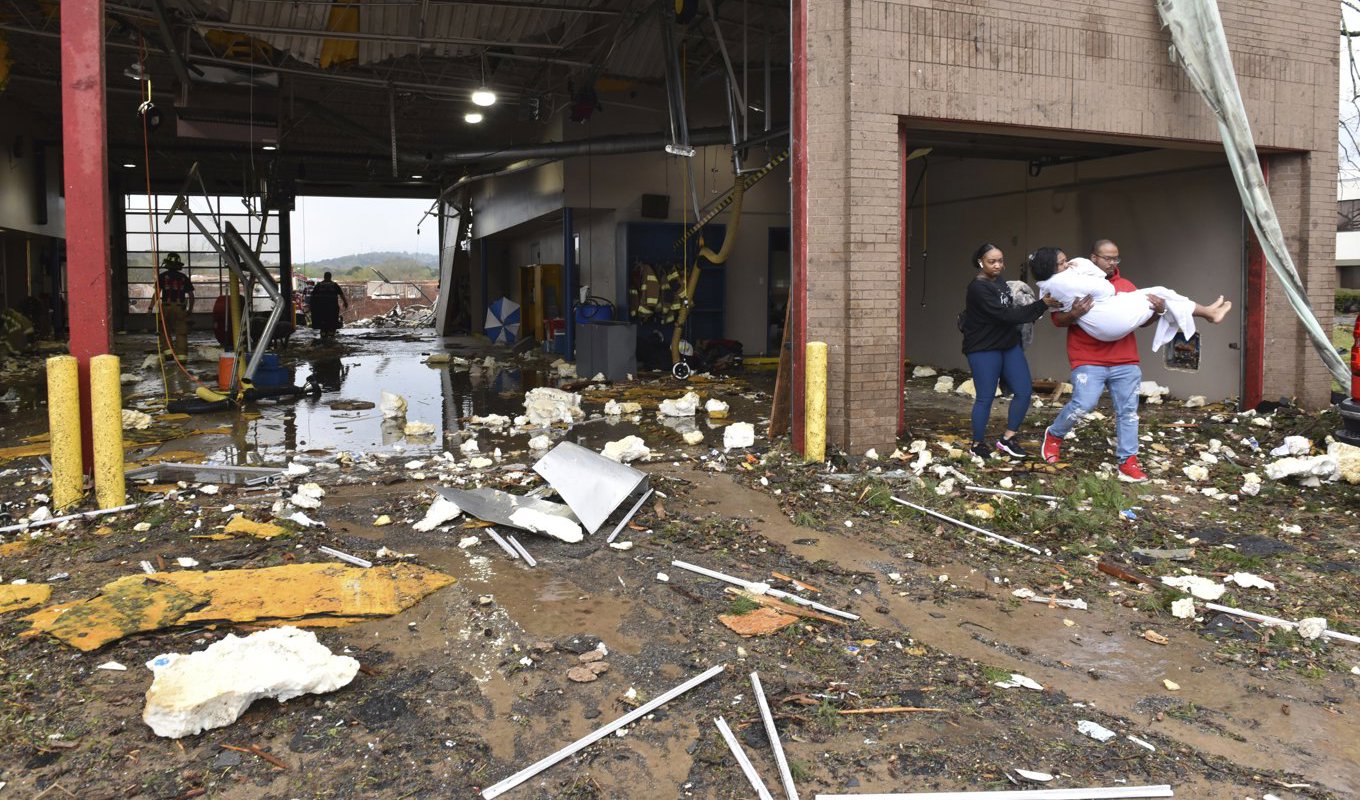 En kvinna bärs ut till en ambulans från en stormhärjad brandstation i Little Rock, Arkansas, USA. Foto: Staci Vandagriff/AP/TT