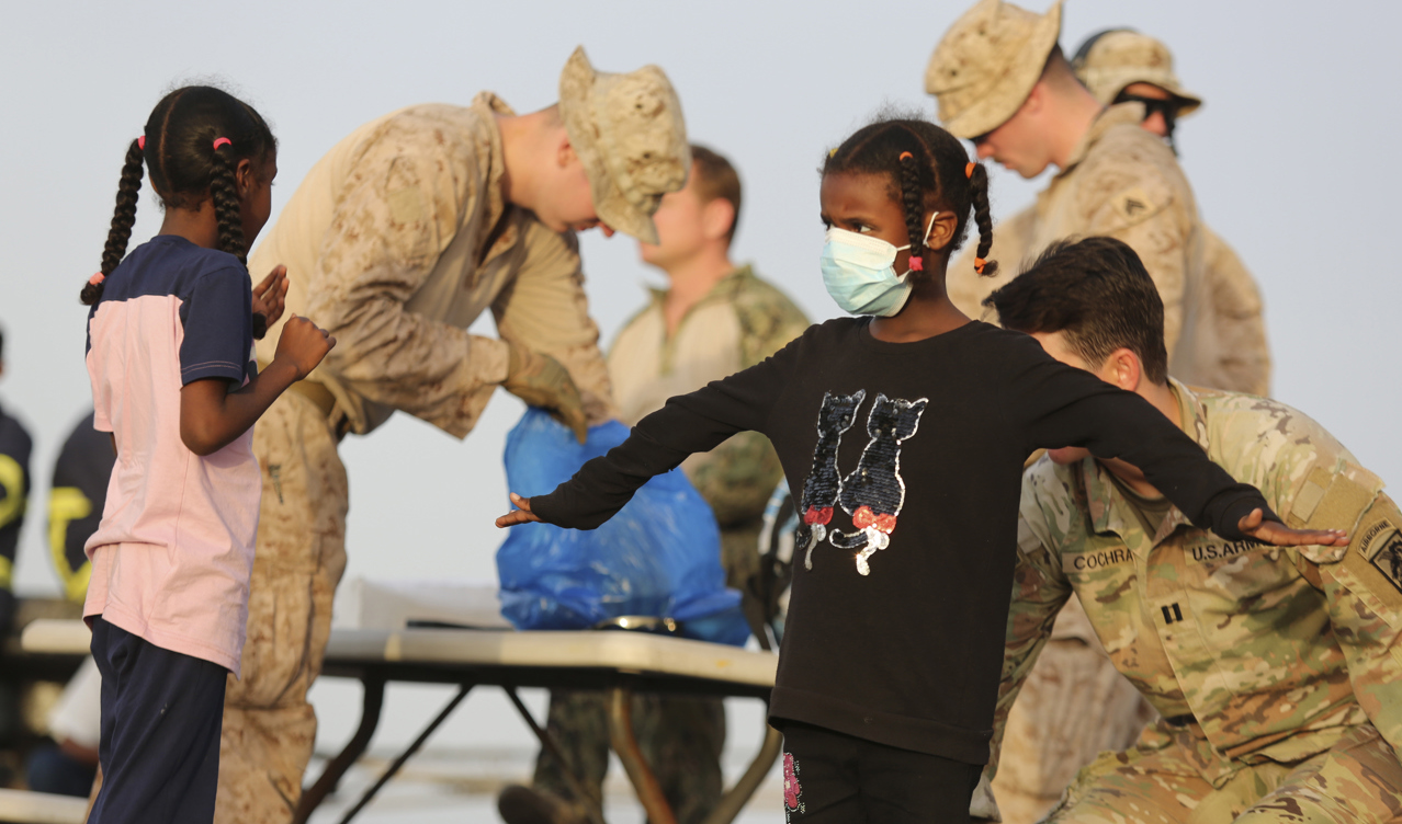 Amerikanska medborgare kroppsvisiteras innan de går ombord ett fartyg i Port Sudan den 30 april. Foto: Smowal Abdalla/AP/TT