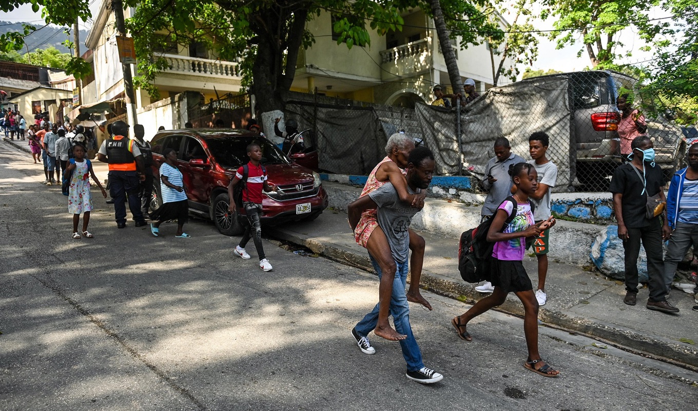 Människor lämnar ett område i Port-au-Prince den 24 april. Foto: Richard Pierrin/AFP via Getty Images