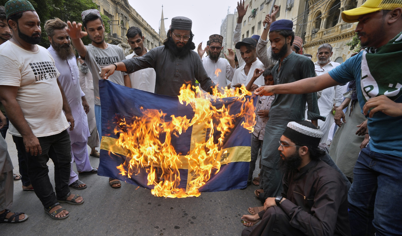 Anhängare till det radikala islamistpartiet Tehreek-e-Labiak bränner en svensk flalgga i Karachi. Foto: Fareed Khan/AP/TT