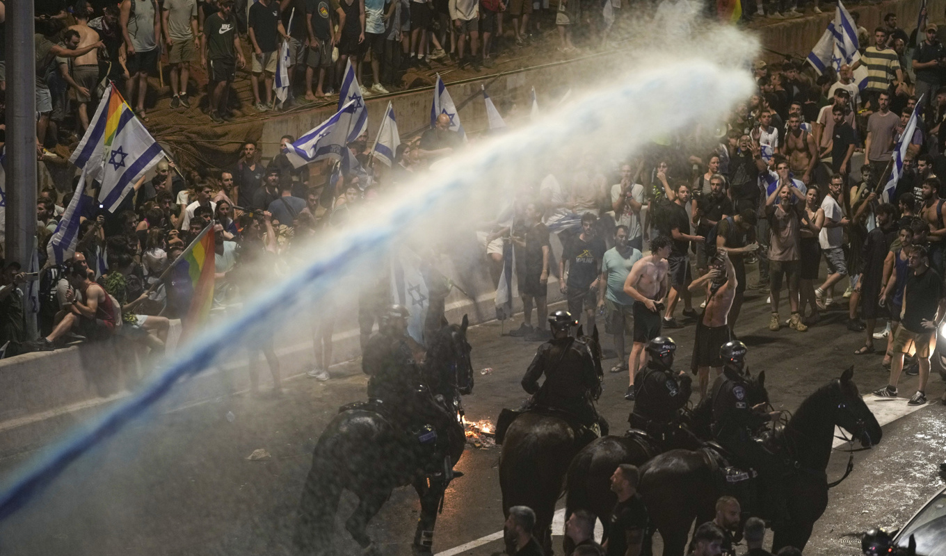 Polis med vattenkanoner skingrar demonstranter i Tel Aviv på måndagen. Foto: Oded Balilty/AP/TT