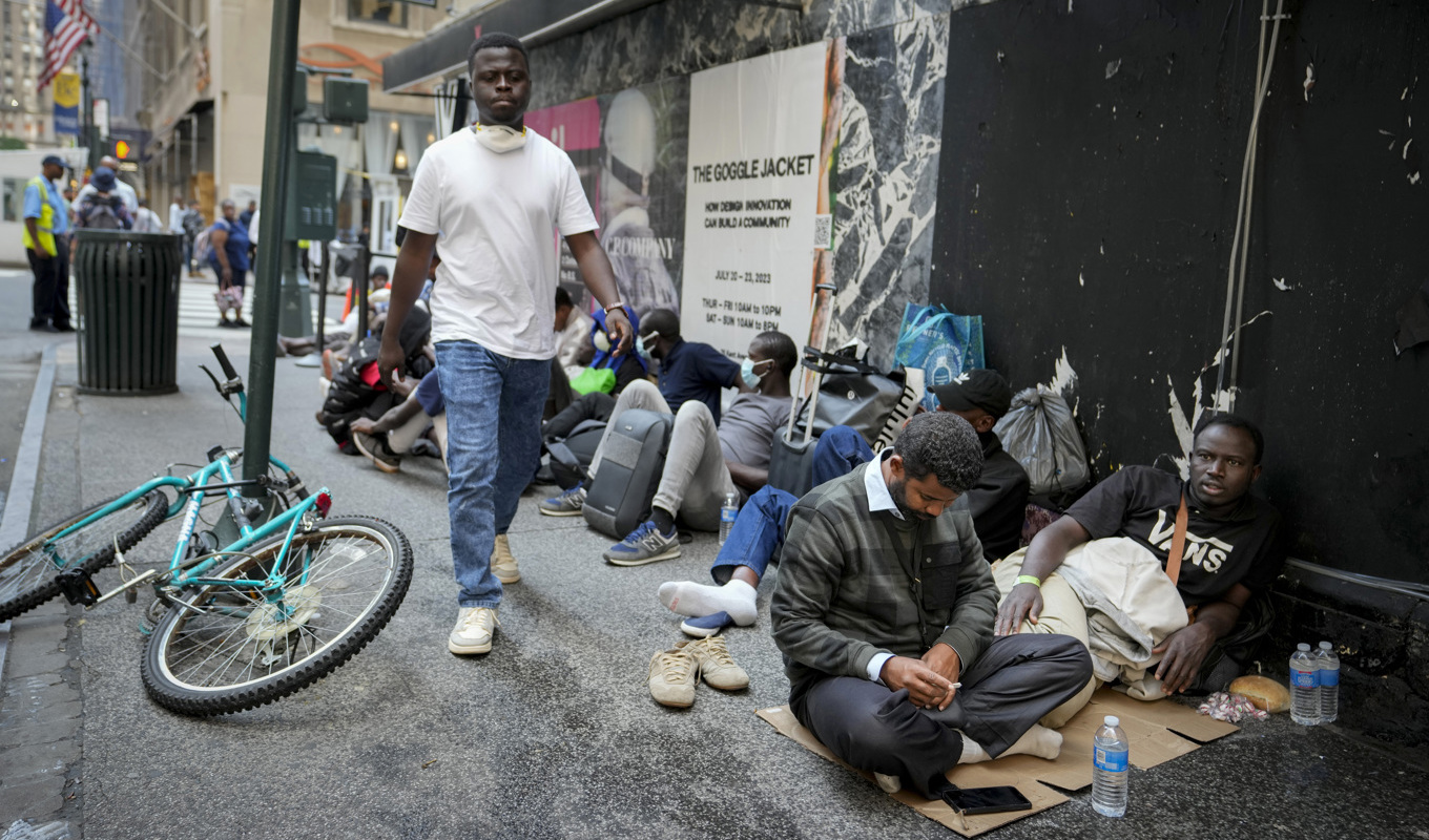 Migranter köar utanför The Roosevelt Hotel i New York, som fungerar som tillfälligt boende för hemlösa. Foto: John Minchillo/AP/TT