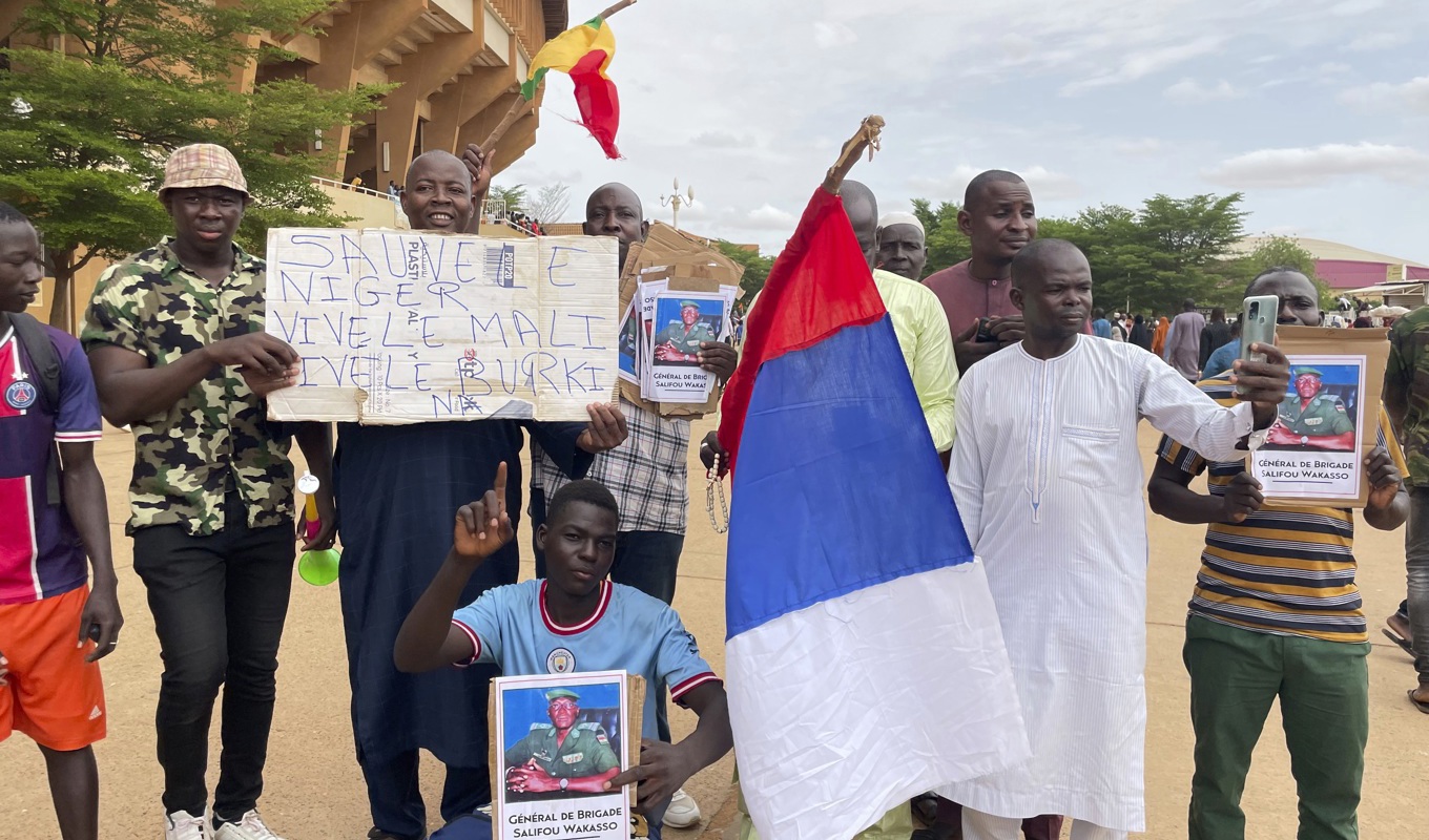 Anhängare till juntan i Niger håller upp ett plakat med den ryska flaggan. Bilden är tagen den 6 augusti. Foto: Sam Mednick/AP/TT