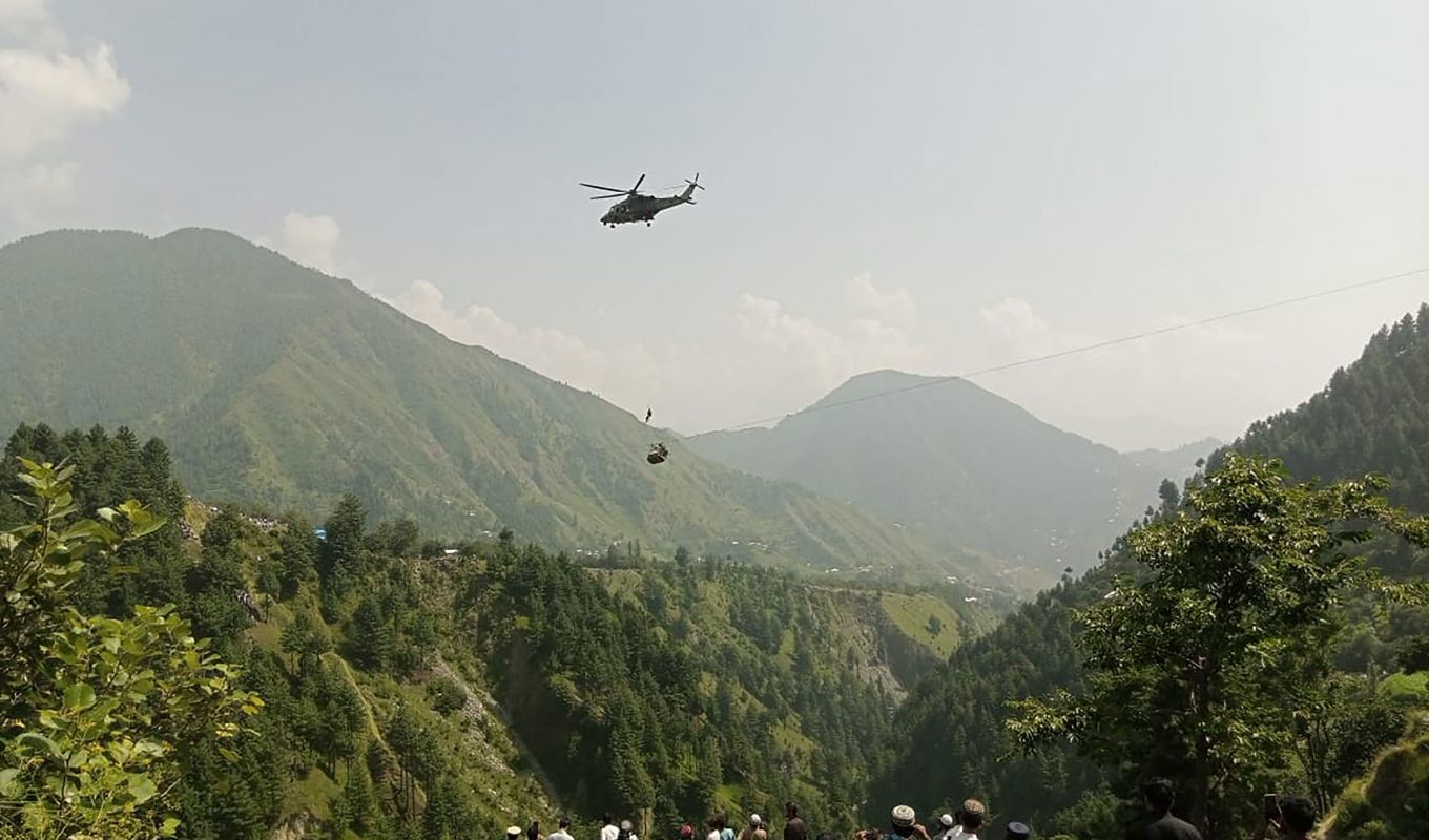 Två vuxna och sex barn har fastnat 275 meter över marken efter att en linbana gått sönder i Pakistan. Foto: AP/TT