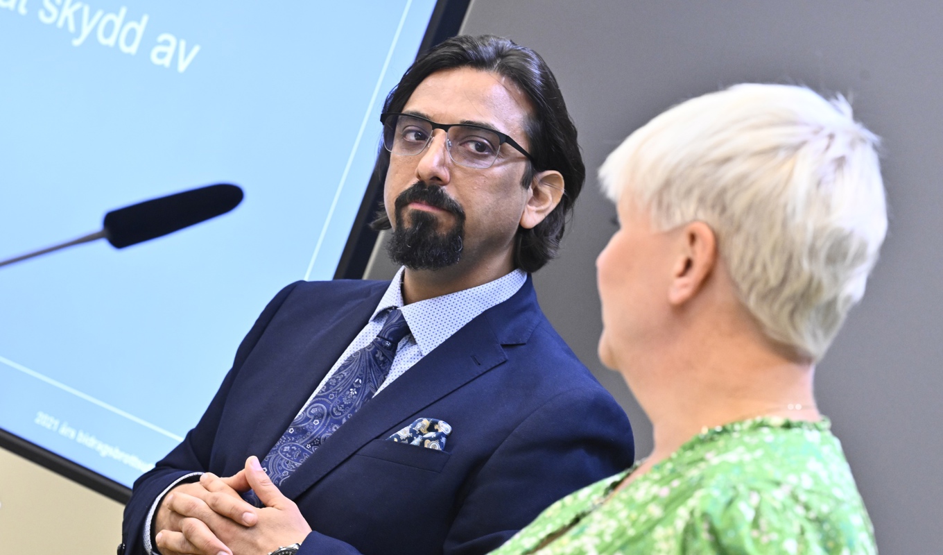 Äldre- och socialförsäkringsminister Anna Tenje tar emot slutbetänkandet från 2021 års bidragsbrottsutredning av utredaren Amir Rostami. Foto: Claudio Bresciani / TT