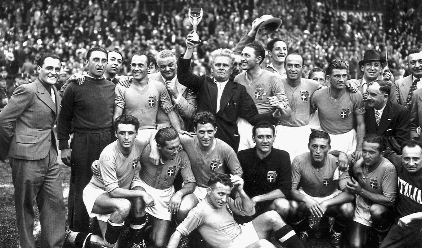Italienska landslaget jublar efter att ha slagit Ungern i VM-finalen 1938. Tränaren Vittorio Pozzo lyfter bucklan. Foto: STAFF/AFP via Getty Images