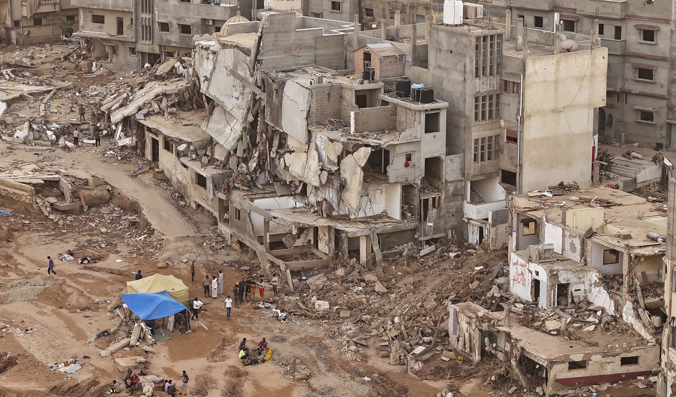 Räddningsarbetare och offers anhöriga sätter upp tält vid rasade byggnader i Darnah, i Libyen. Bilden togs i måndags. Foto: Muhammad J. Elalwany/AP/TT