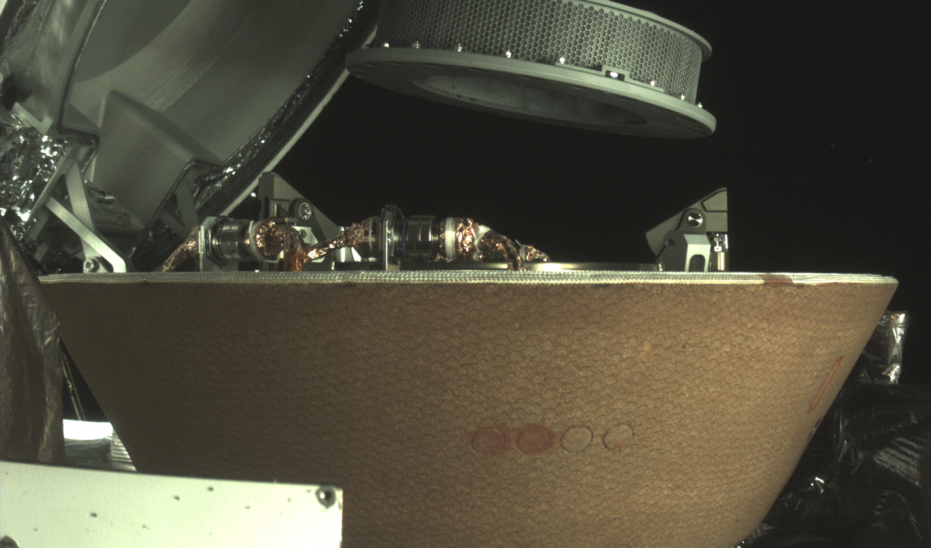 En bild från Nasa visar en provbehållare ovanför en kapsel på Osiris Rex-sonden nära asteroiden Bennu. Arkivbild. Foto: Nasa/AP/TT