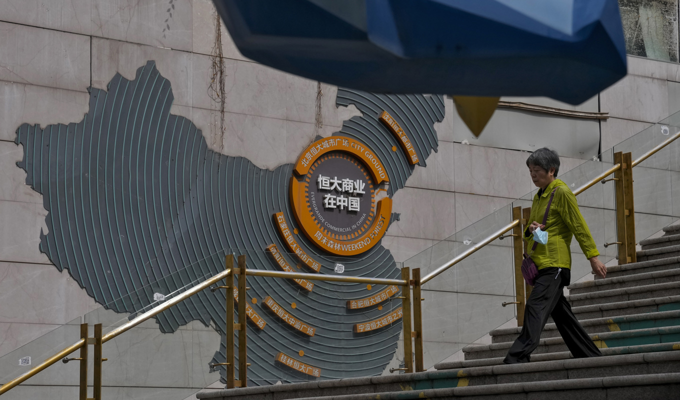 En kvinna passerar en karta över Evergrandes byggprojekt i Kina i Peking. Arkivbild Foto: Andy Wong/AP/TT