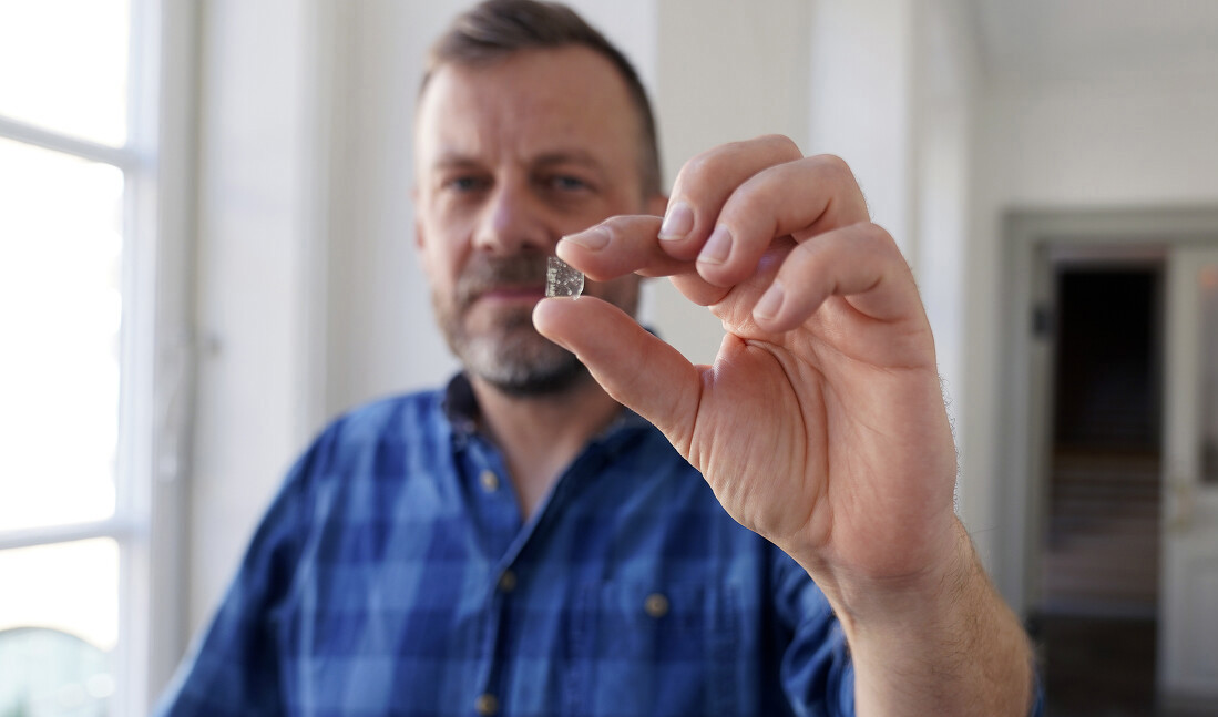 Mads Dengsø Jessen, forskare vid Danmarks Nationalmuseum, visar upp en bit fönsterglas från vikingatiden. Foto: John Fhær Engedal Nissen/Nationalmuseum