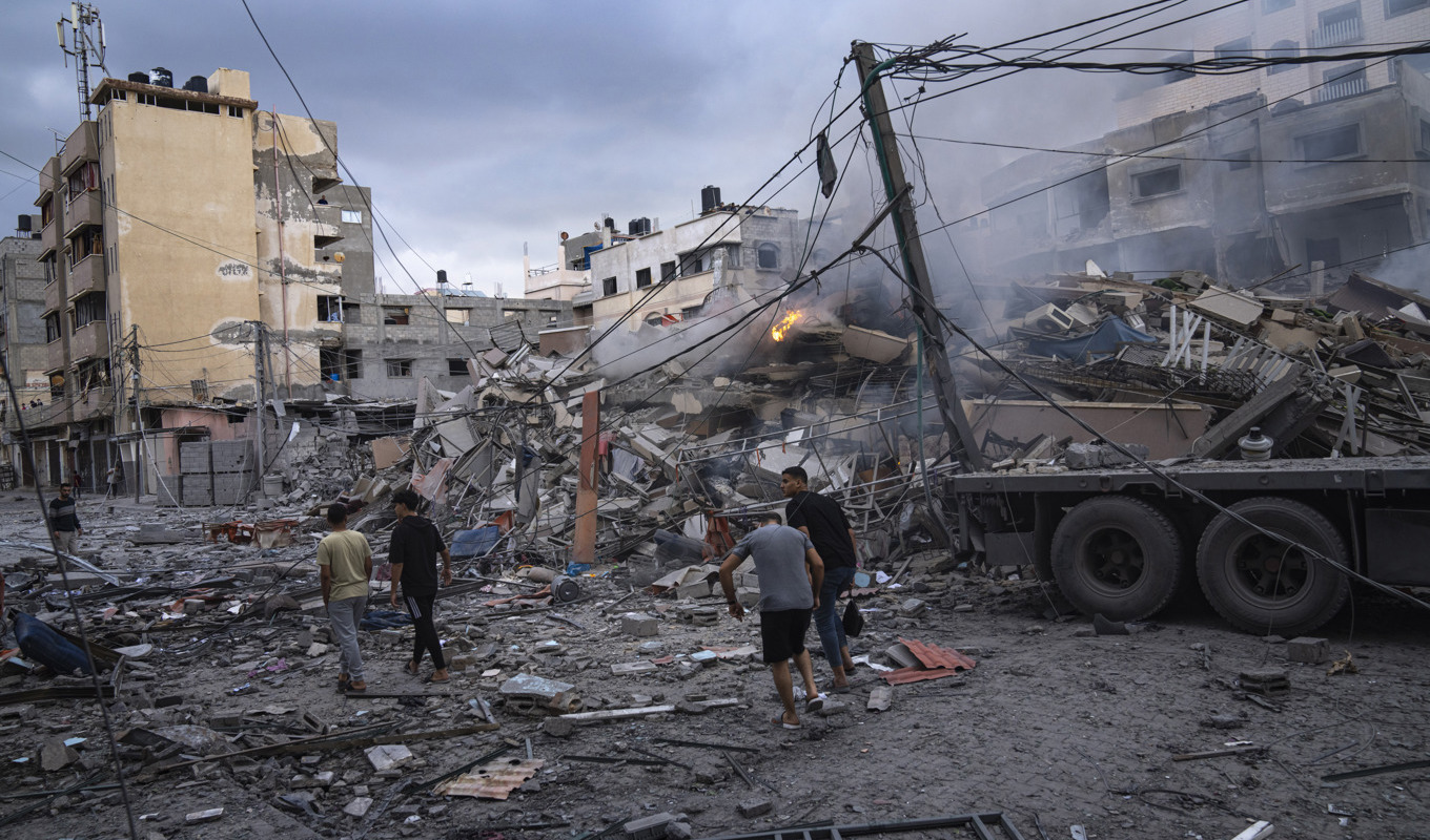 Boende i Gaza City inspekterar resterna av en byggnad efter att Israel under natten till tisdagen gjort flygräder mot Hamasmål. Foto: Fatima Shbair/AP/TT