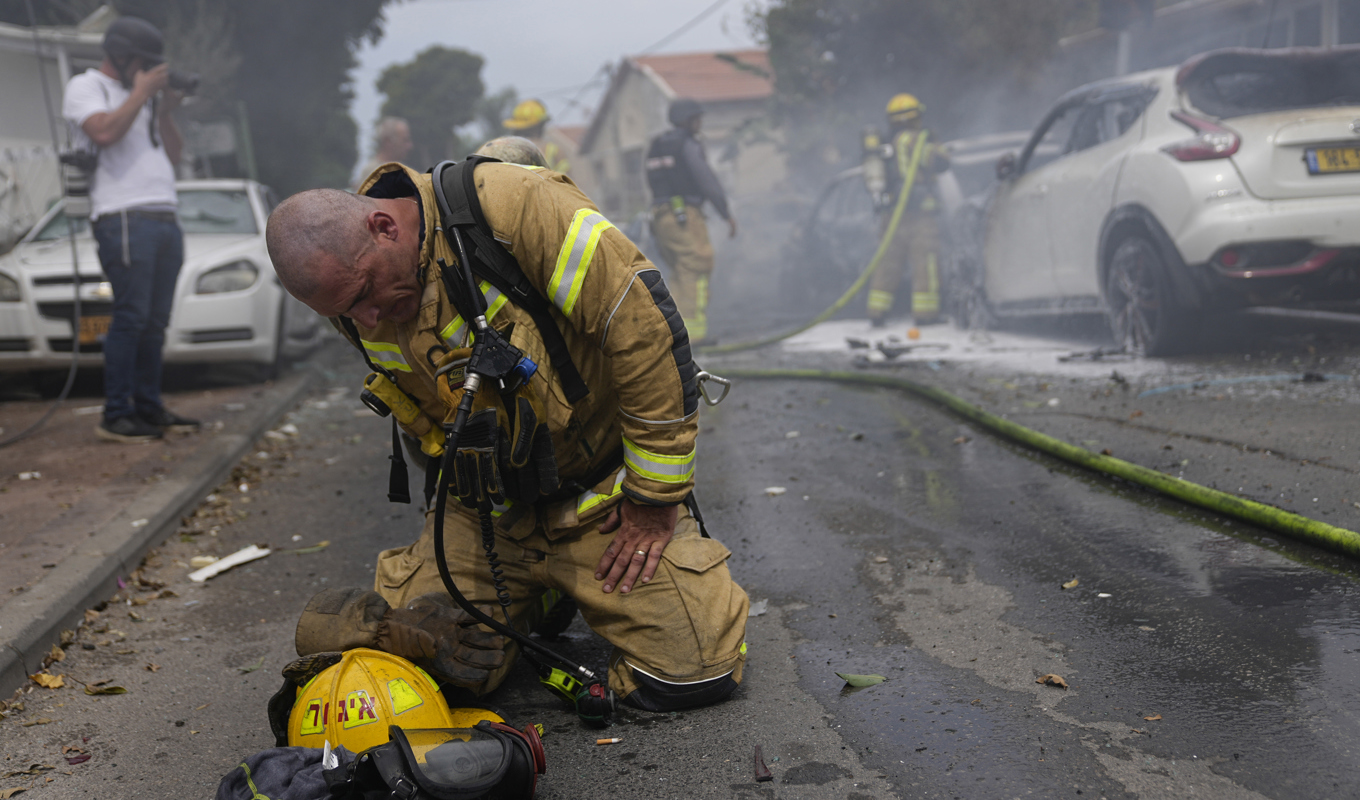 En israelisk brandman tar igen sig vid ett släckningsarbete i Ashkelon, där bilar börjat brinna till följd av en raketattack. Bilden togs i måndags. Foto: Ohad Zwigenberg/AP/TT