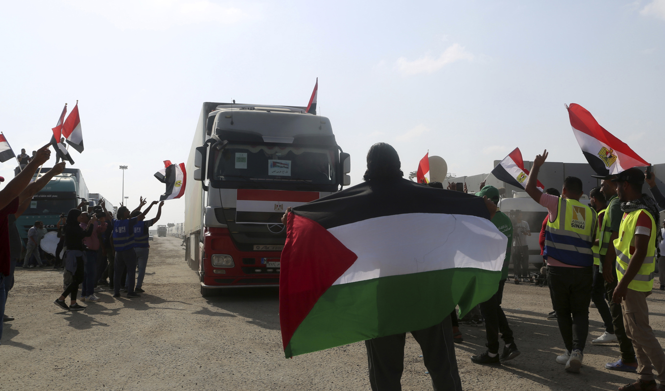 Volontärer tar emot en lastbil med humanitär hjälp till Gaza vid gränsövergången i Rafah. Foto: Mohammed Asad/AP/TT