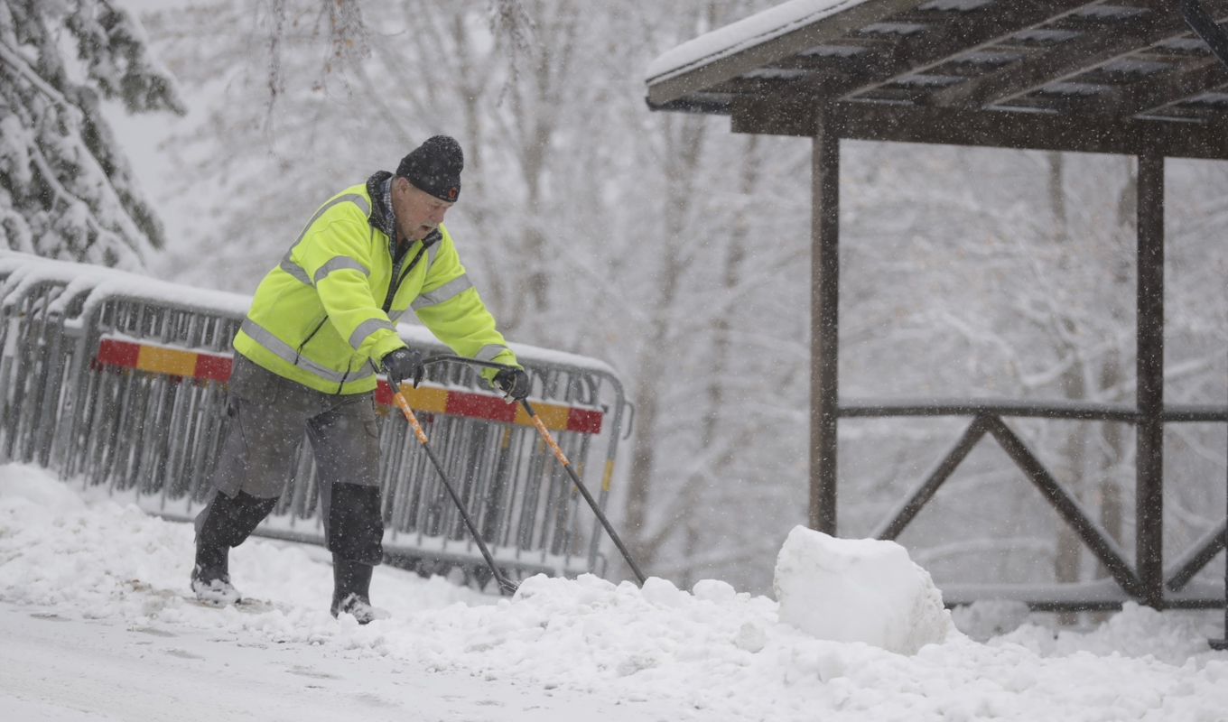 Torne Persson skottar snö utanför Sundsvall där SMHI har varnat för snö i kombination med hårda vindar. Foto: Mats Andersson/TT