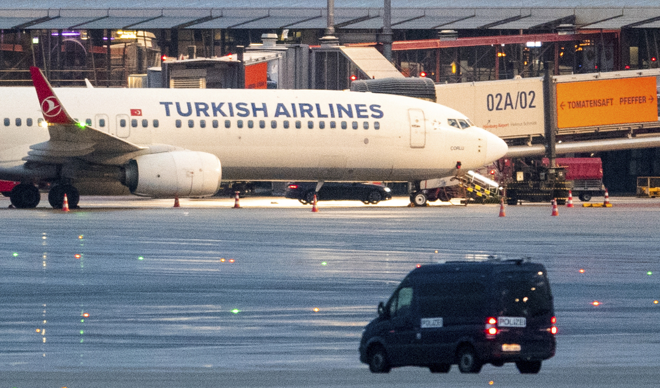 En polisbil vid det flygplan på Hamburgs flygplats som gisslantagaren befann sig vid. Foto: Daniel Bockwoldt/AP/TT