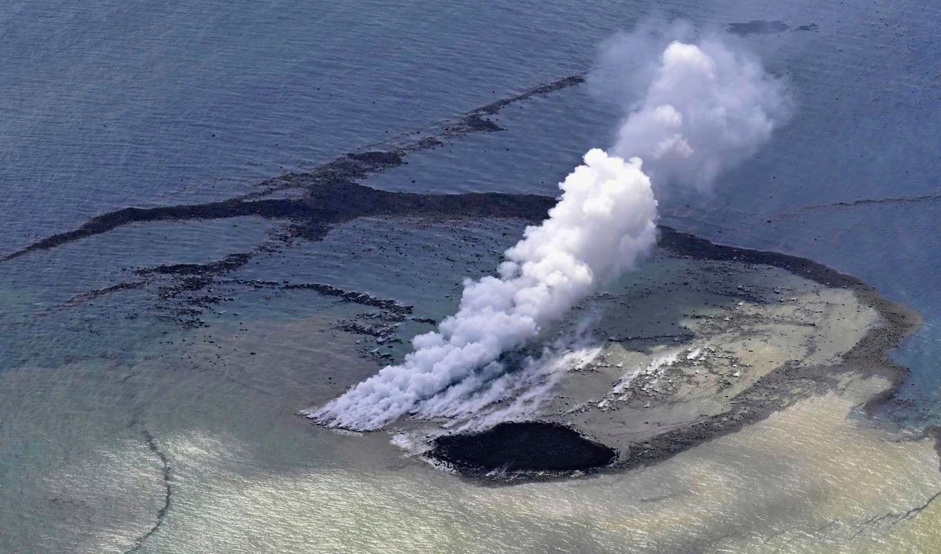 Ånga bolmar ur vattnet där ett vulkanutbrott har skapat en ny ö. Foto: AP/Kyodo/TT