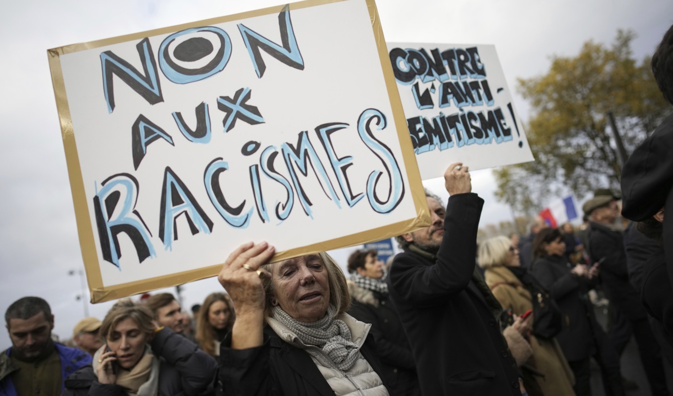Nej till rasism, står det på kvinnans plakat under en demonstration mot antisemitism i Paris under lördagen. Foto: Christophe Ena/AP/TT
