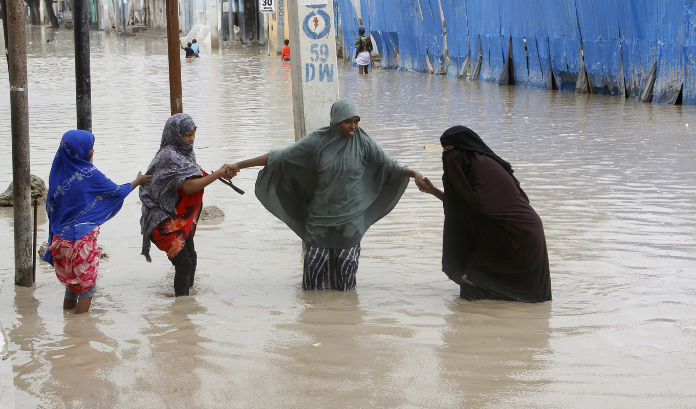 Kvinnor vadar över en översvämmad gata i Somalias huvudstad Mogadishu på måndagen. Foto: Farah Abdi Warsameh/AP/TT