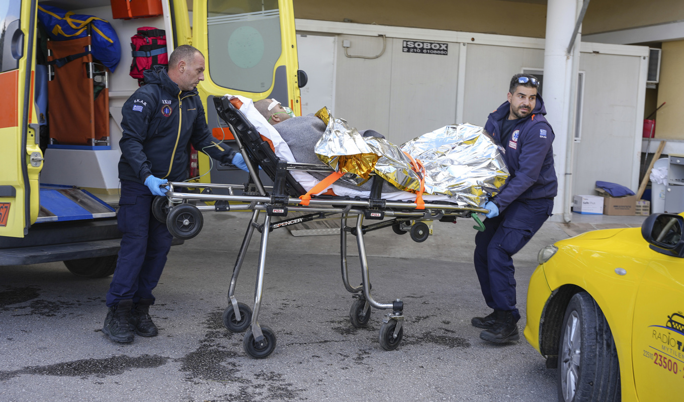 Sjukvårdspersonal lyfter in en överlevare i ambulans. Foto: Panagiotis Balaskas/AP/TT