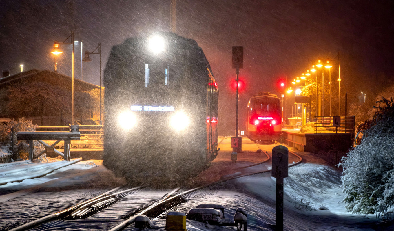 Ett tåg lämnar stationen i Wehrheim utanför Frankfurt på tisdagsmorgonen. Tåget till höger på väg in till Frankfurt kunde inte åka vidare på grund av att träd fallit över spåren. Foto: Michael Probst/AP/TT