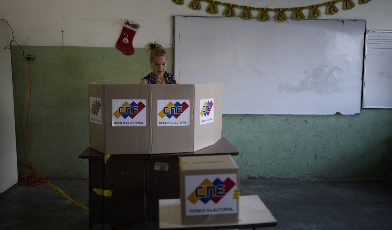 En kvinna i Venzuelas huvdstad Caracas lägger sin röst i samband med folkomröstningen om regionen Essequibo, som tillhör Guyana. Foto: Ariana Cubillos/AP/TT