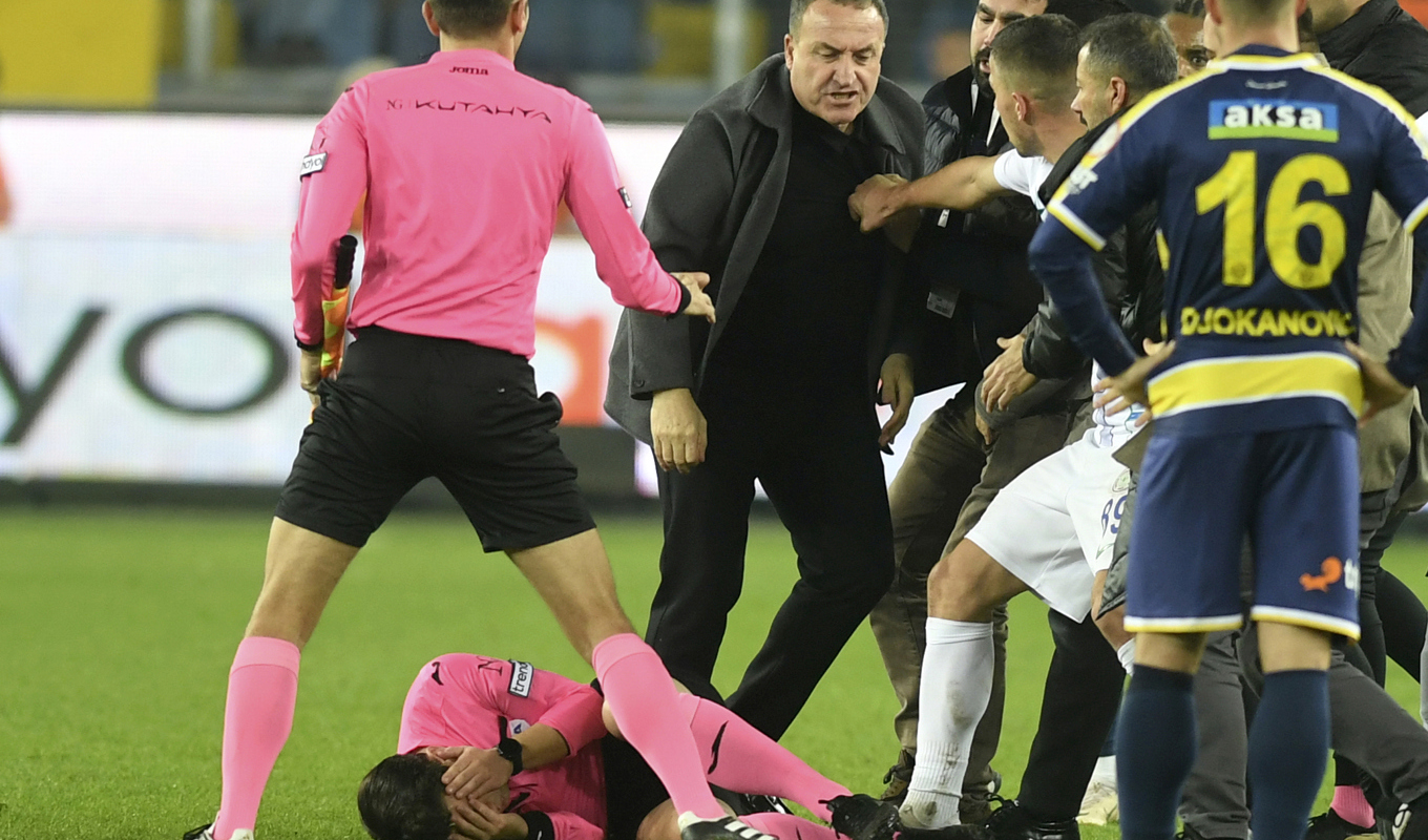 Domaren Halil Umut Meler håller sig för ansiktet efter att ha blivit attackerad av Ankaragücus ordförande Faruk Koca, i mitten, i slutskedet av måndagens turkiska ligamatch mella Nakaragücu och Rizespor. Foto: Abdurrahman Antakyali/Depo Photos/AP/TT