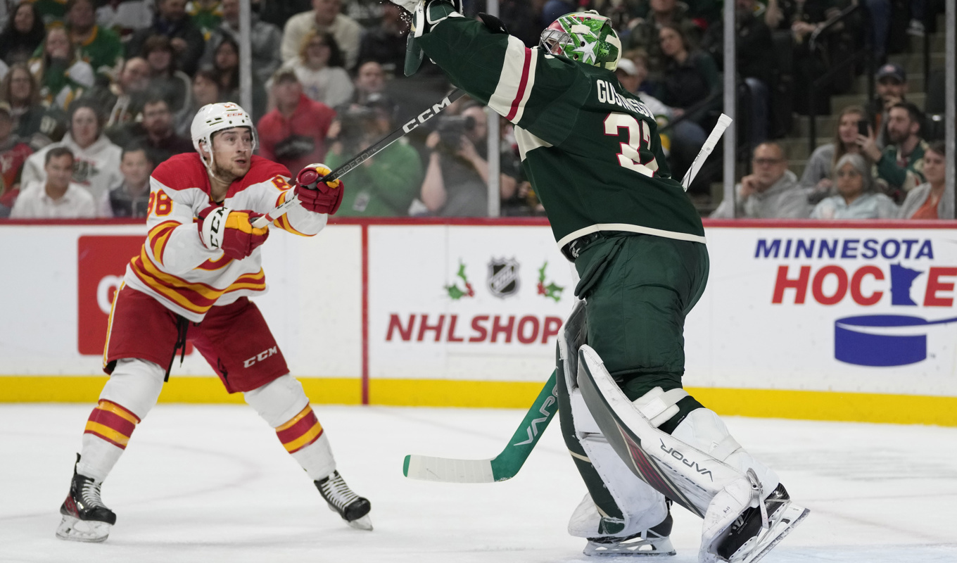 Minnesotas målvakt Filip Gustavsson blockerar ett skott framför Calgarys Andrew Mangiapane i den andra perioden. Foto: Abbie Parr/AP/TT