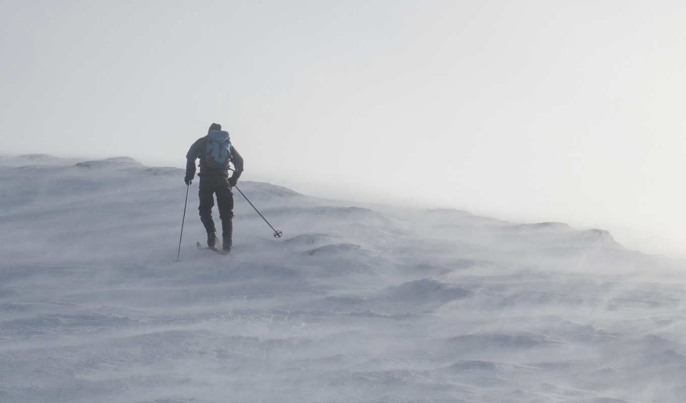 En skidåkare kämpar i kraftig blåst. Arkivbild. Foto: Paul Kleiven/AP/TT