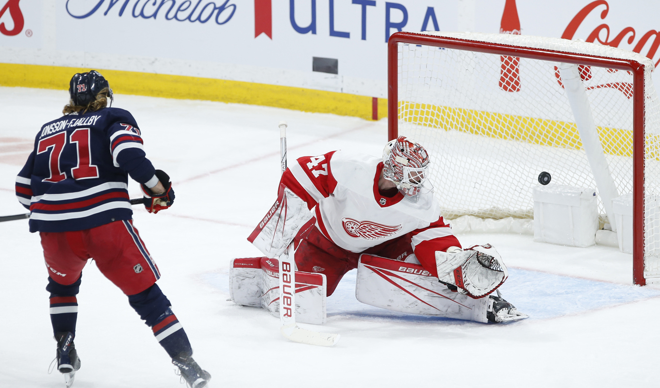 Axel Jonsson Fjällby sätter pucken bakom Detroits målvakt James Reimer. Foto: John Woods/The Canadian Press via AP/TT
