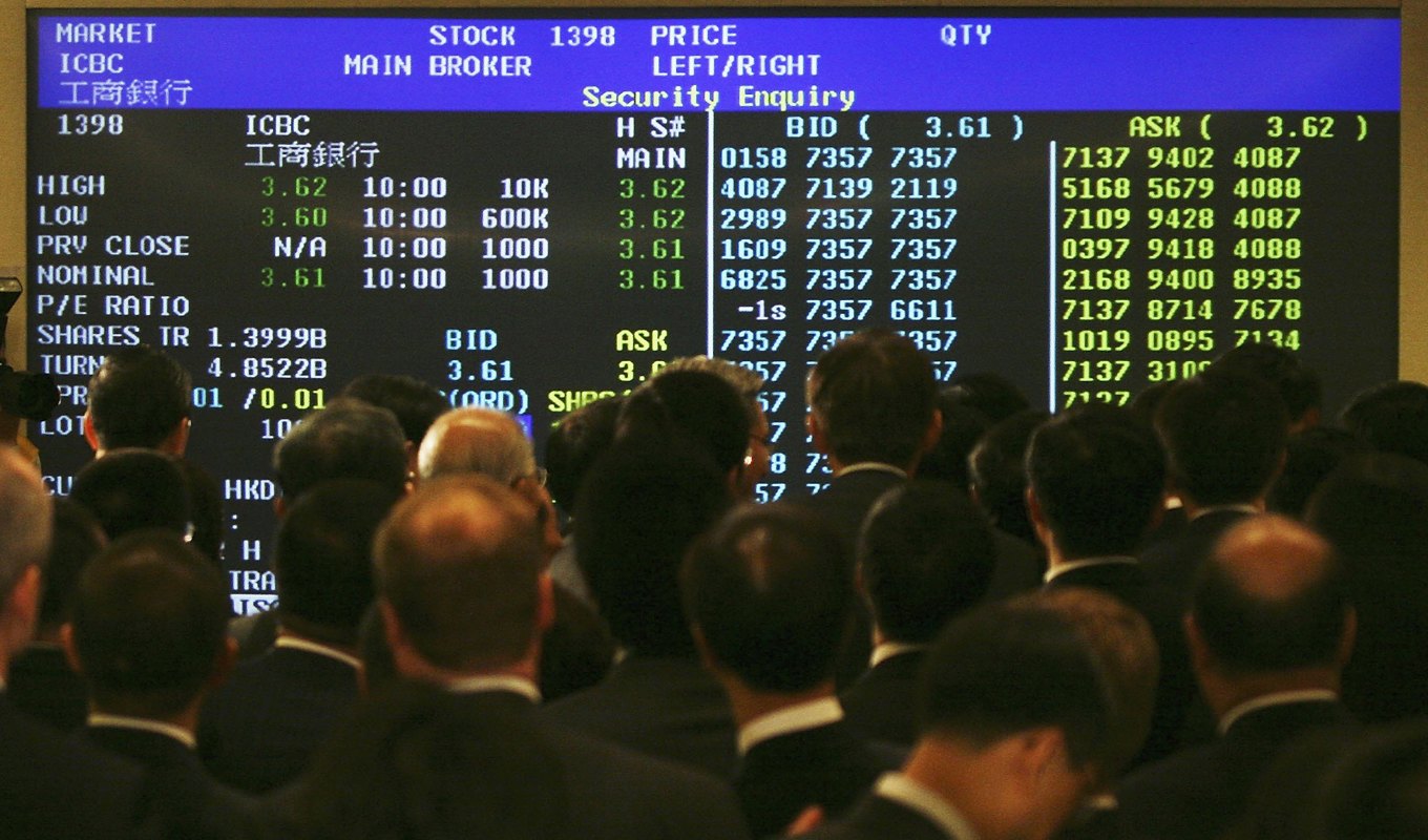 Människor tittar på en elektronisk tavla i Hongkong. Foto: MN Chan/Getty Images