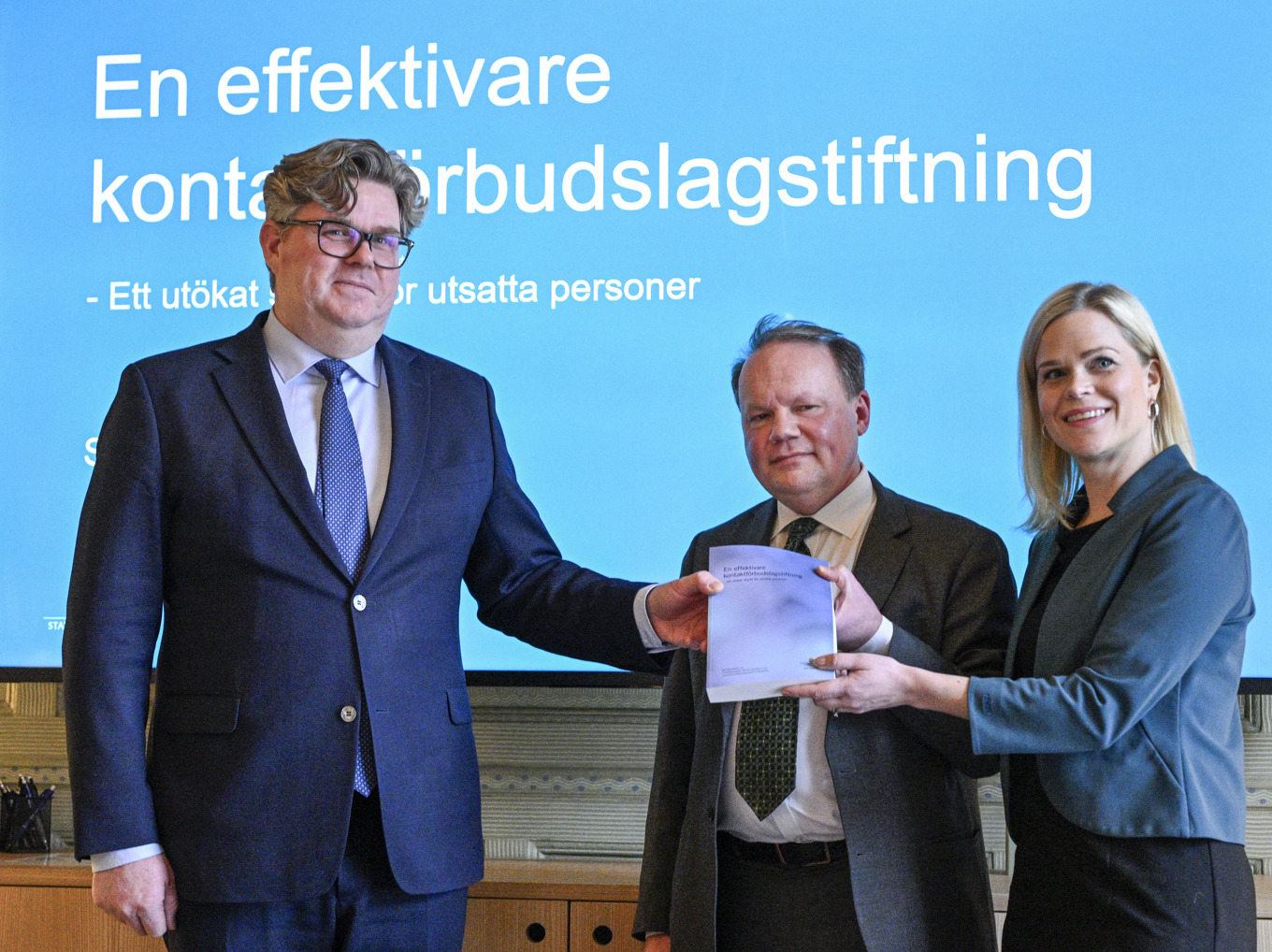 Justitieminister Gunnar Strömmer (M) och jämställdhetsminister Paulina Brandberg (L) under en pressträff där de tar emot betänkandet av utredningen om en översyn av kontaktförbudslagstiftningen. I mitten särskilda utredaren Lars Wallinder. Foto: Anders Wiklund/TT