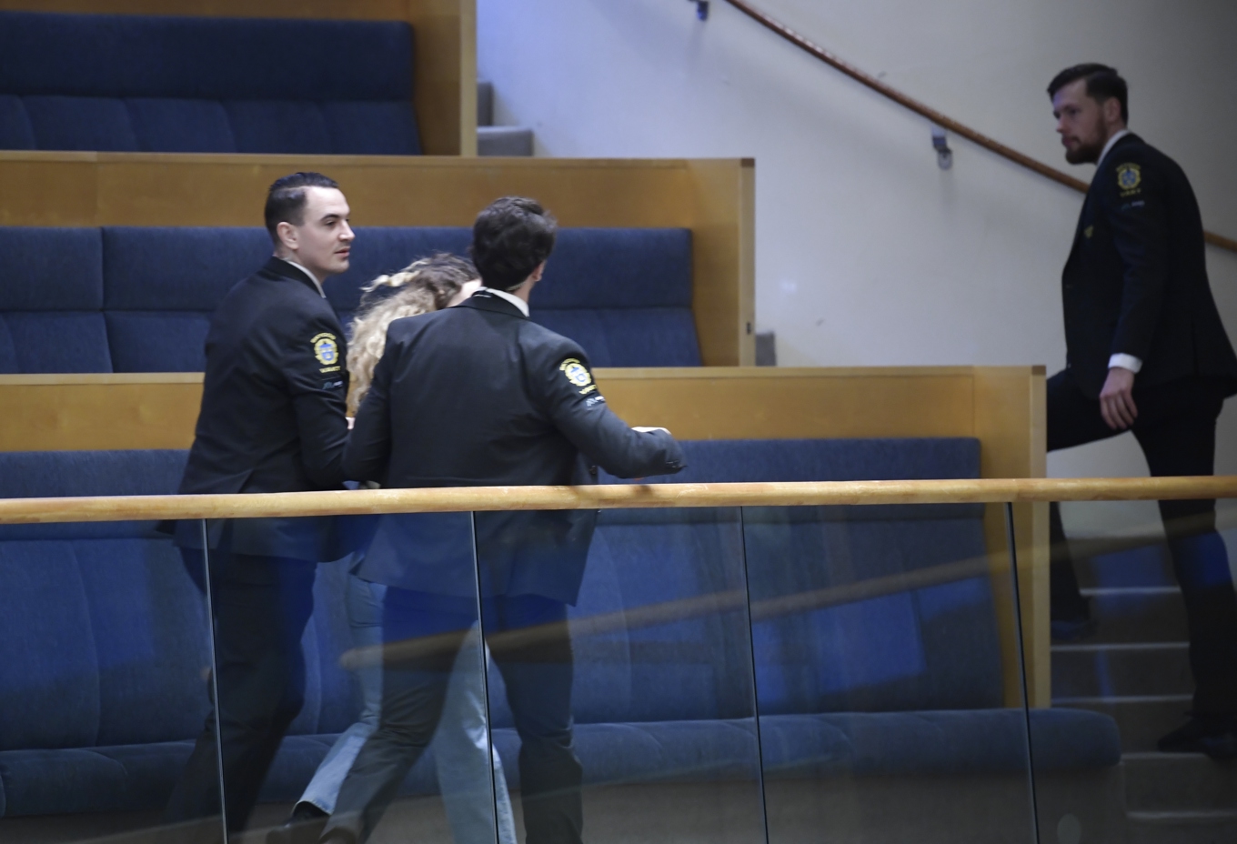 Riksdagens vakter ingriper mot en kvinna som började skrika under utrikesminister Tobias Billströms (M) anförande. Foto: Samuel Steén/TT