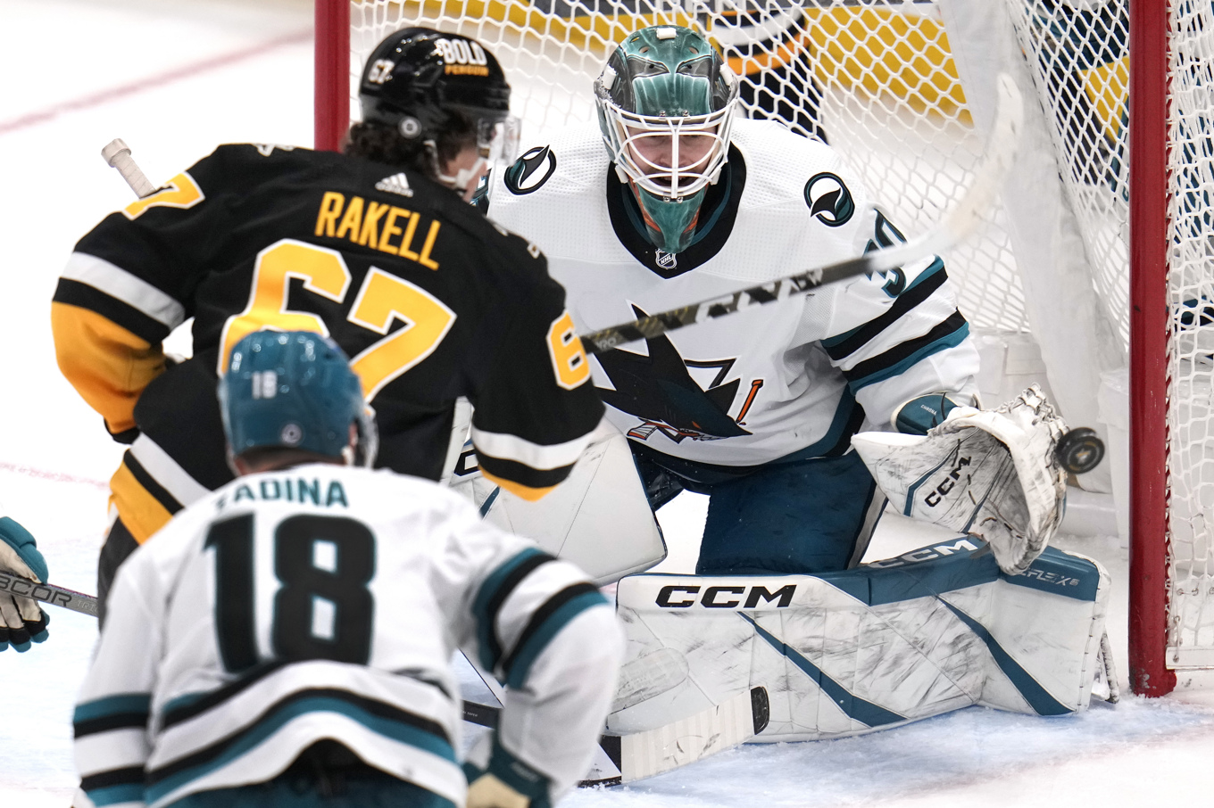 Pittsburghs Rickard Rakell (67) i kamp framför San Joses svenske målvakt Magnus Chrona under mötet som slutade med 6–3-vinst för Pittsburgh. Foto: Gene J. Puskar/AP/TT