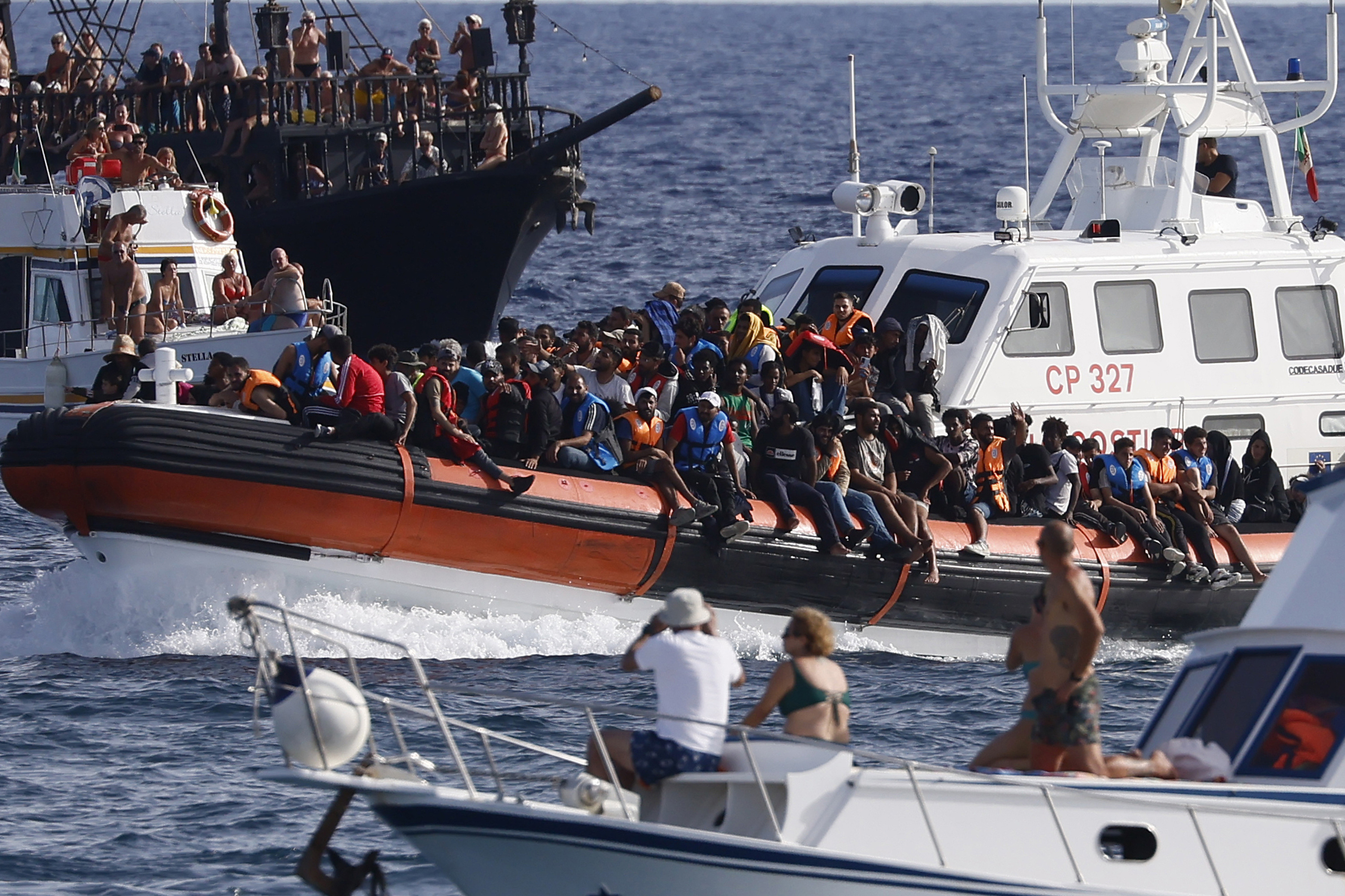 Migranter på väg in till hamnen i Lampedusa ombord på ett italiensk kustbevakningsfartyg. Arkivbild. Foto: Cecilia Fabiano/La Presse/AP/TT
