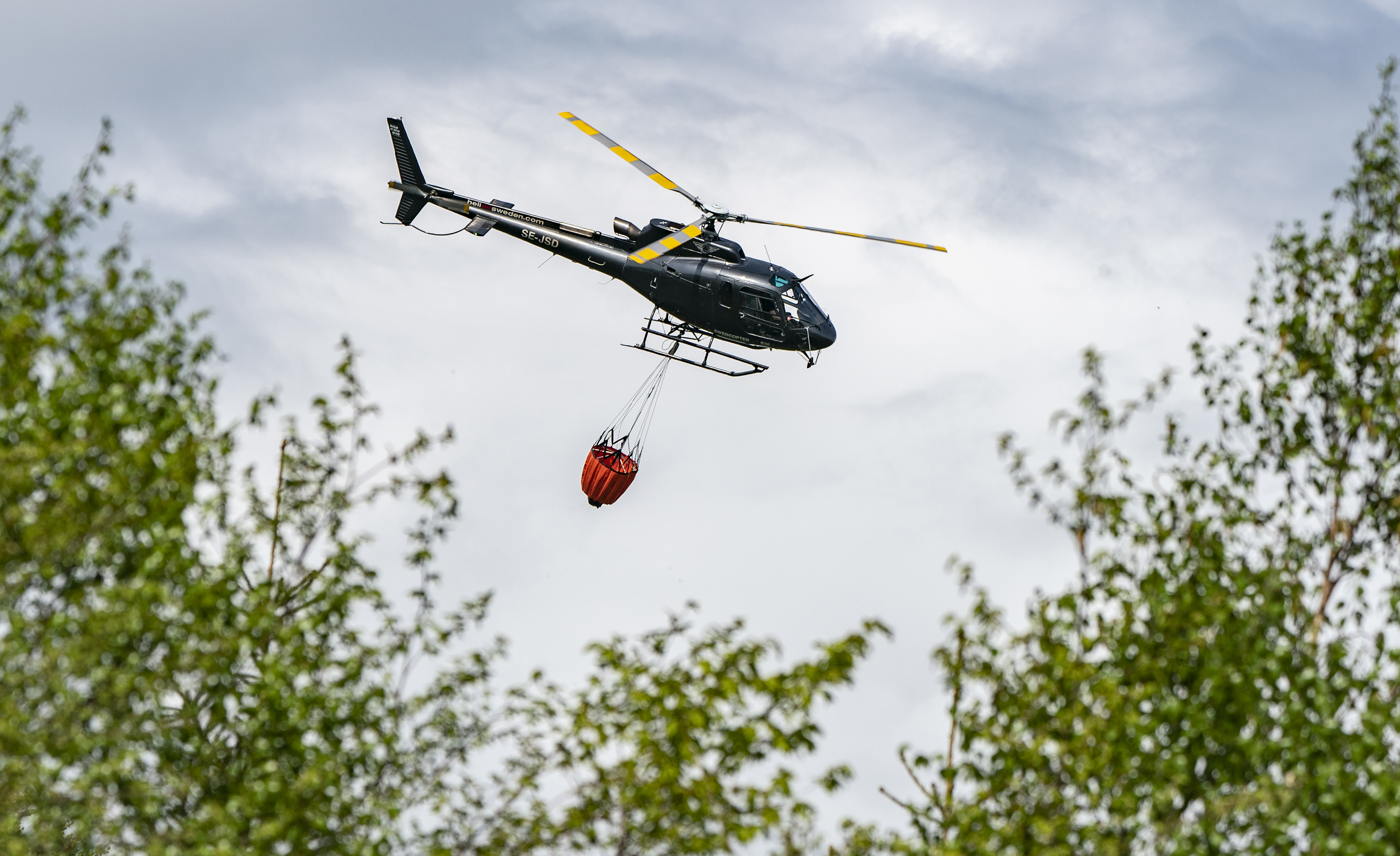 Två helikoptrar jobbar med branden norr om Gnarp. Arkivbild. Foto: Johan Nilsson/TT