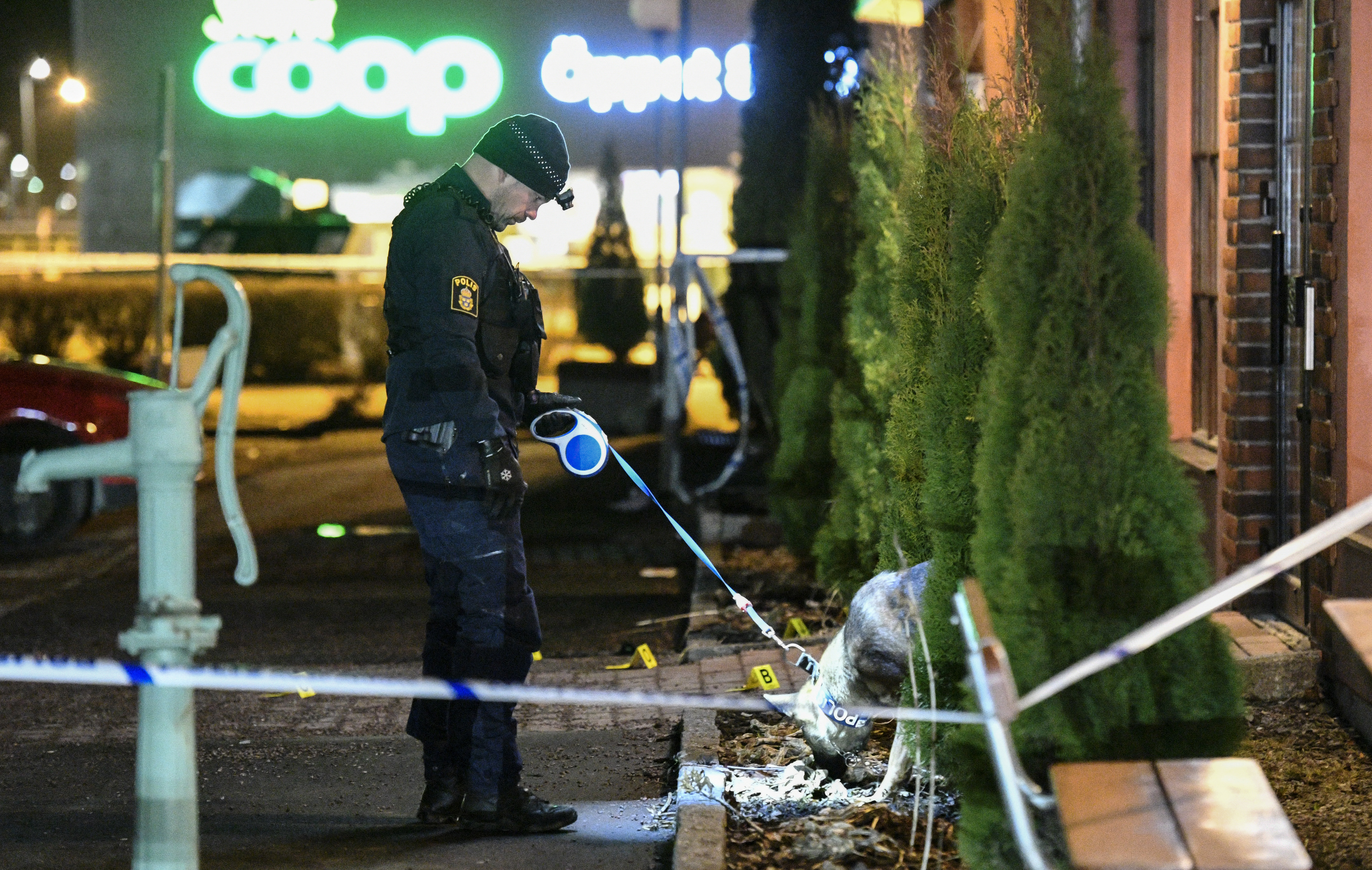 Polis med hund undersöker den plats utanför en restaurang i handelsområdet Boländerna i Uppsala där en man i 40-årsåldern sköts till döds i april 2017. Arkivbild. Foto: Johan Nilsson/TT