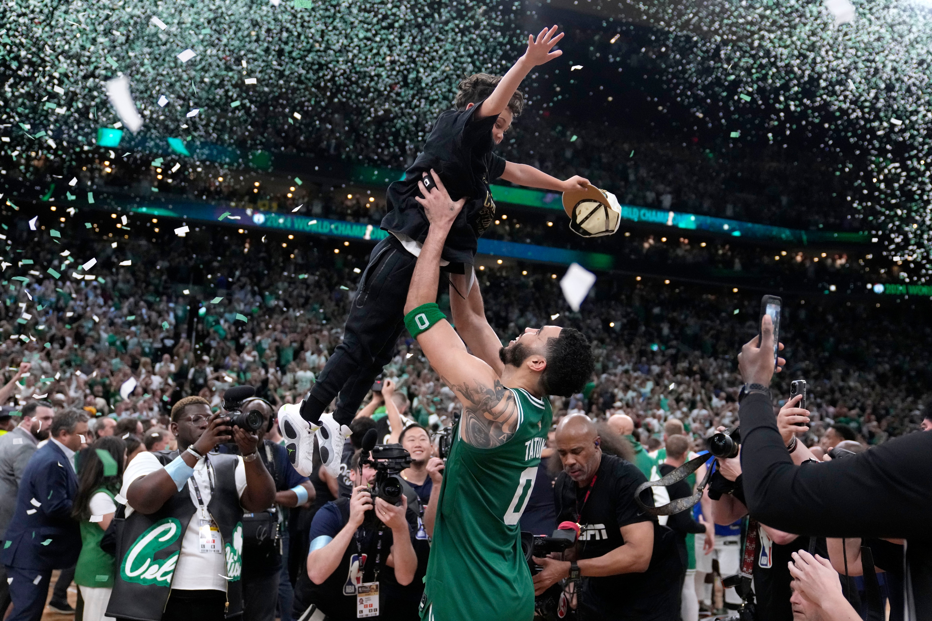 Bostonforwarden Jayson Tatum lyfter upp sin son efter att ha vunnit NBA-finalen mot Dallas. Foto: Charles Krupa/AP/TT