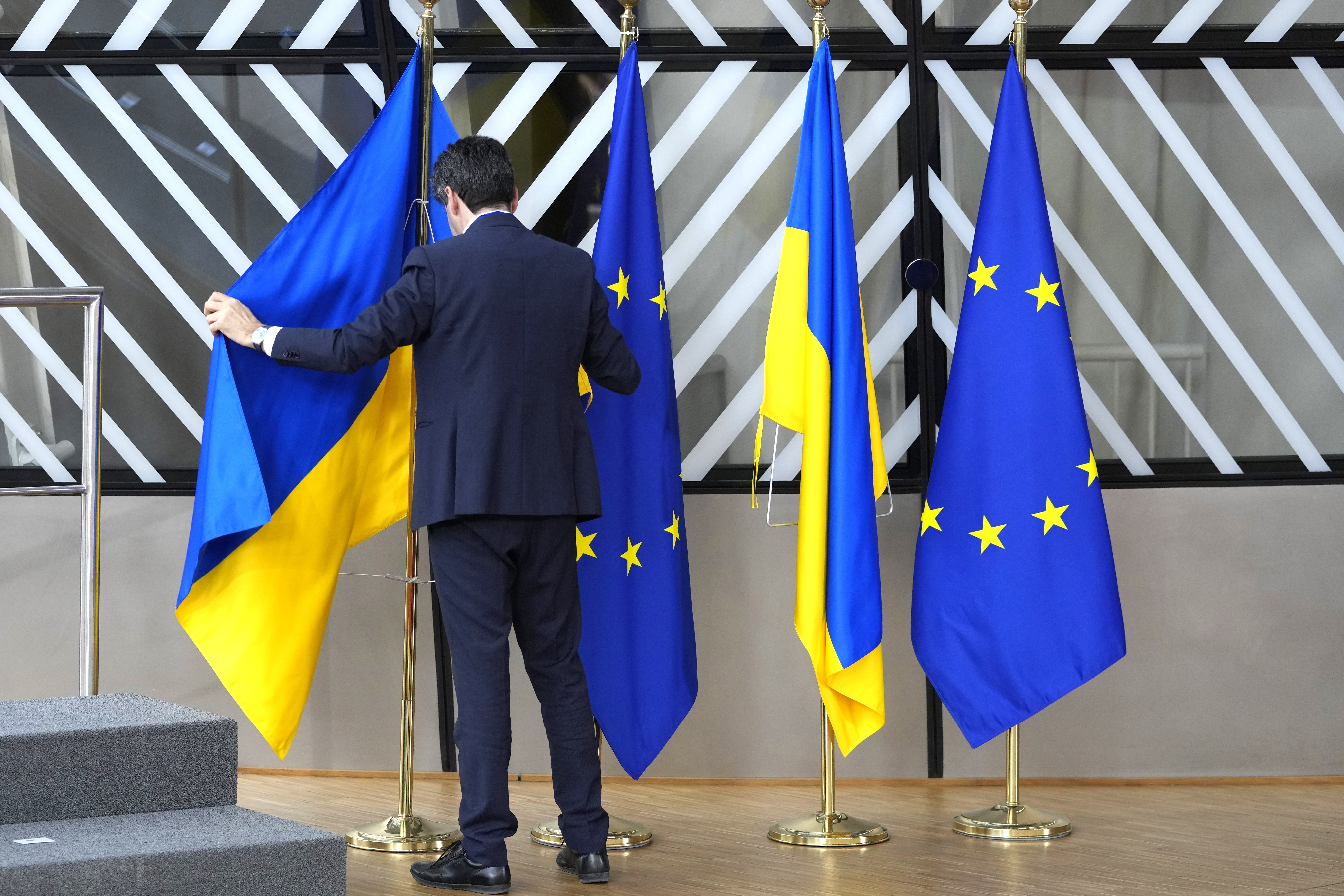 Den ukrainska flaggan hängs på plats inför ett EU-toppmöte i Bryssel 2023. Nu börjar landet sin långa process för att själv bli en del av unionen. Arkivbild. Foto: Virginia Mayo/AP/TT