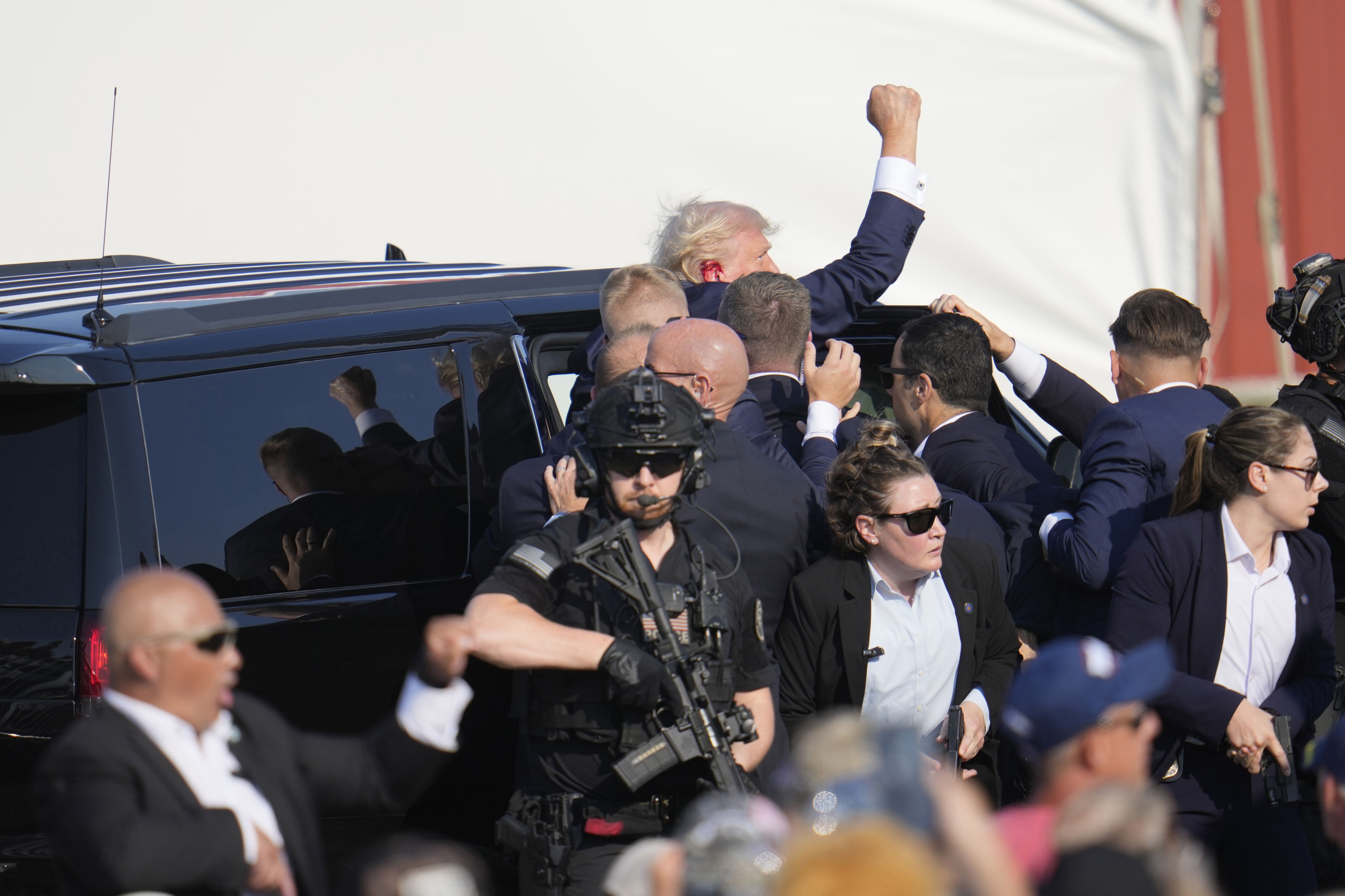 Republikanen och expresidenten Donald Trump förs in i en bil efter mordförsöket mot honom under ett politiskt massmöte i Butler i Pennsylvania. Foto: Gene J. Puskar/AP/TT