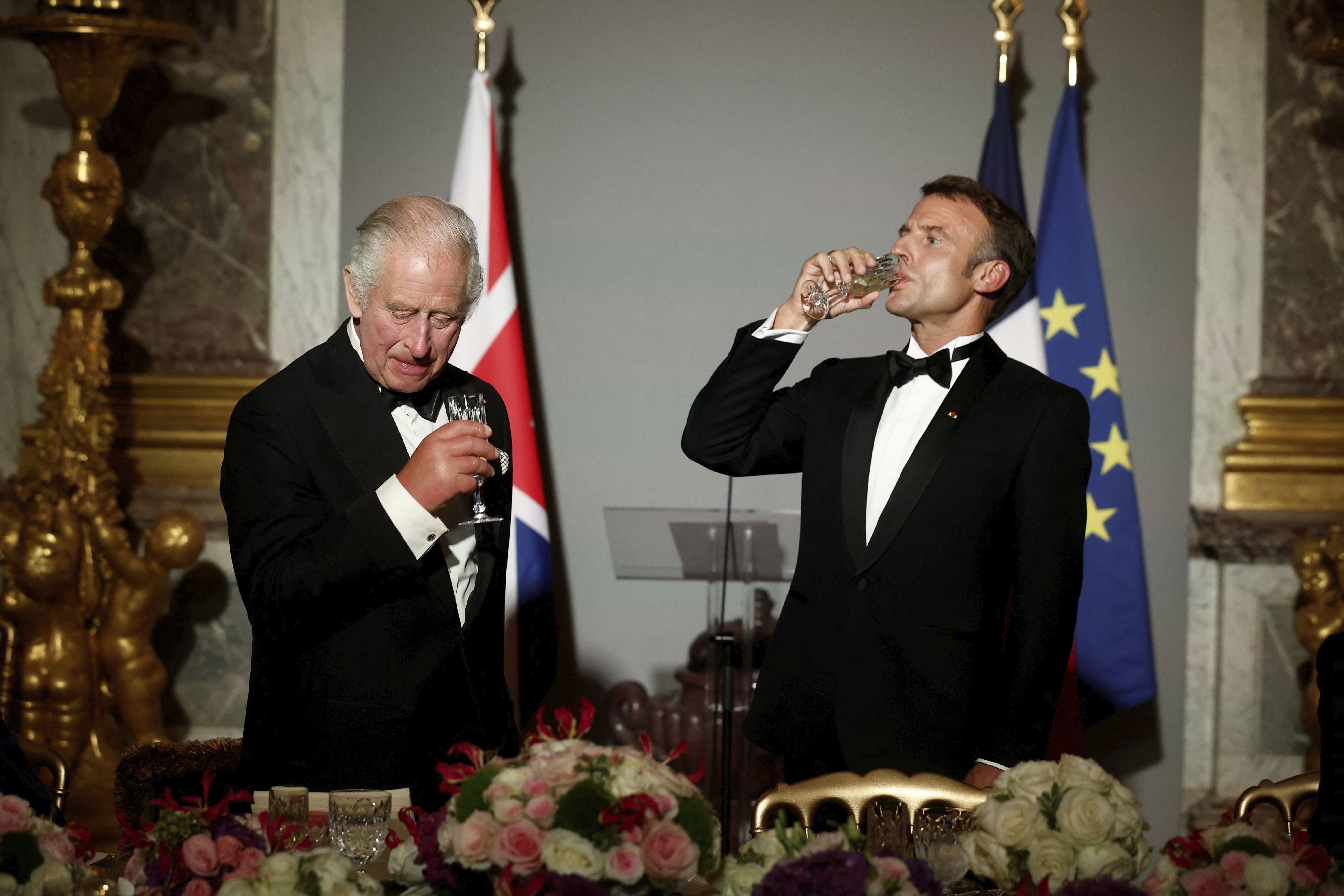 President Macron skålar med kung Charles i spegelsalen i slottet Versailles. Foto: Benoit Tessier/AP/TT