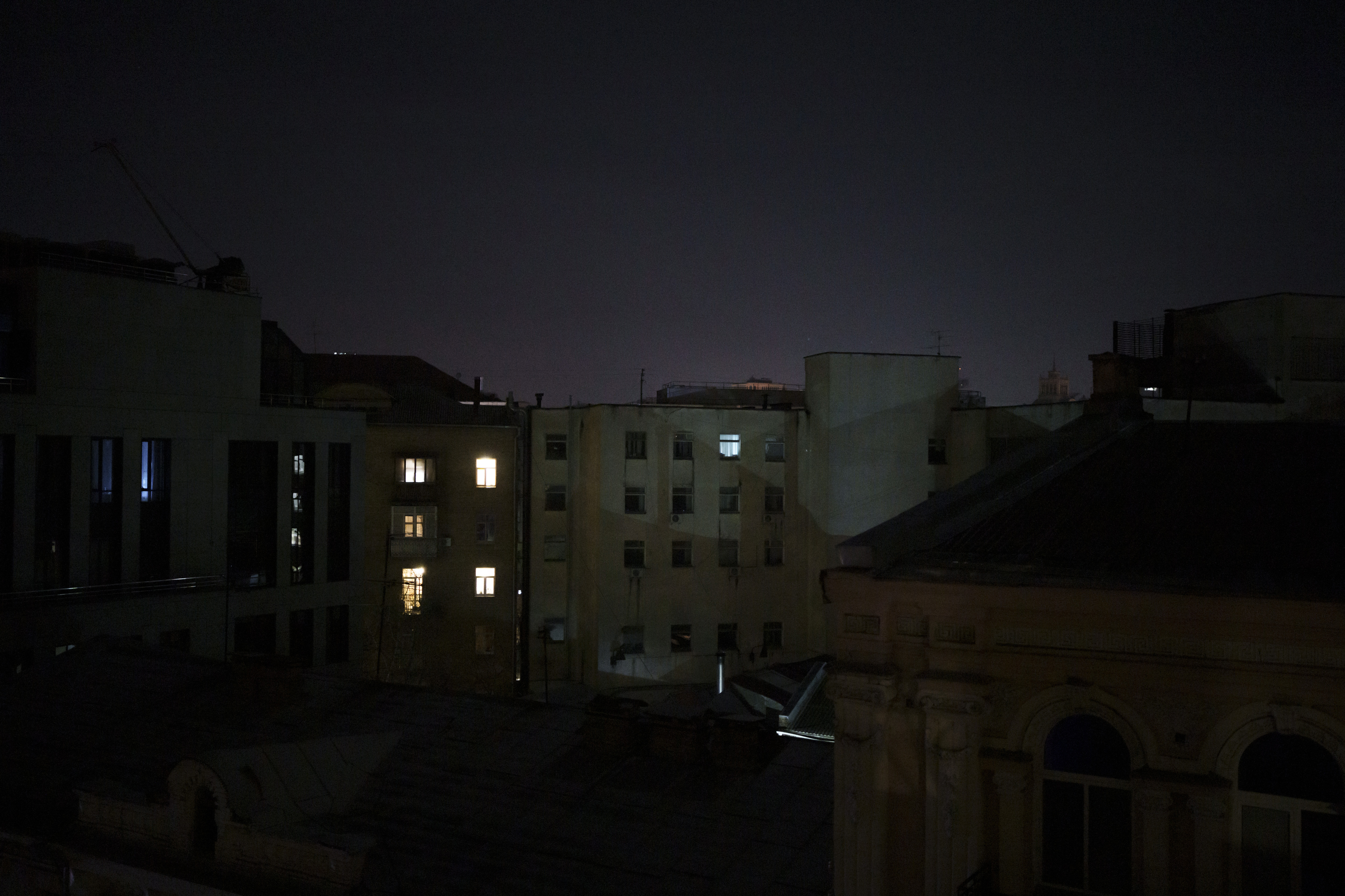Några lägenheter är upplysta under ett strömavbrott på nyårsafton i Kiev, Ukraina, lördagen den 31 december 2022. Foto: Felipe Dana/AP/TT