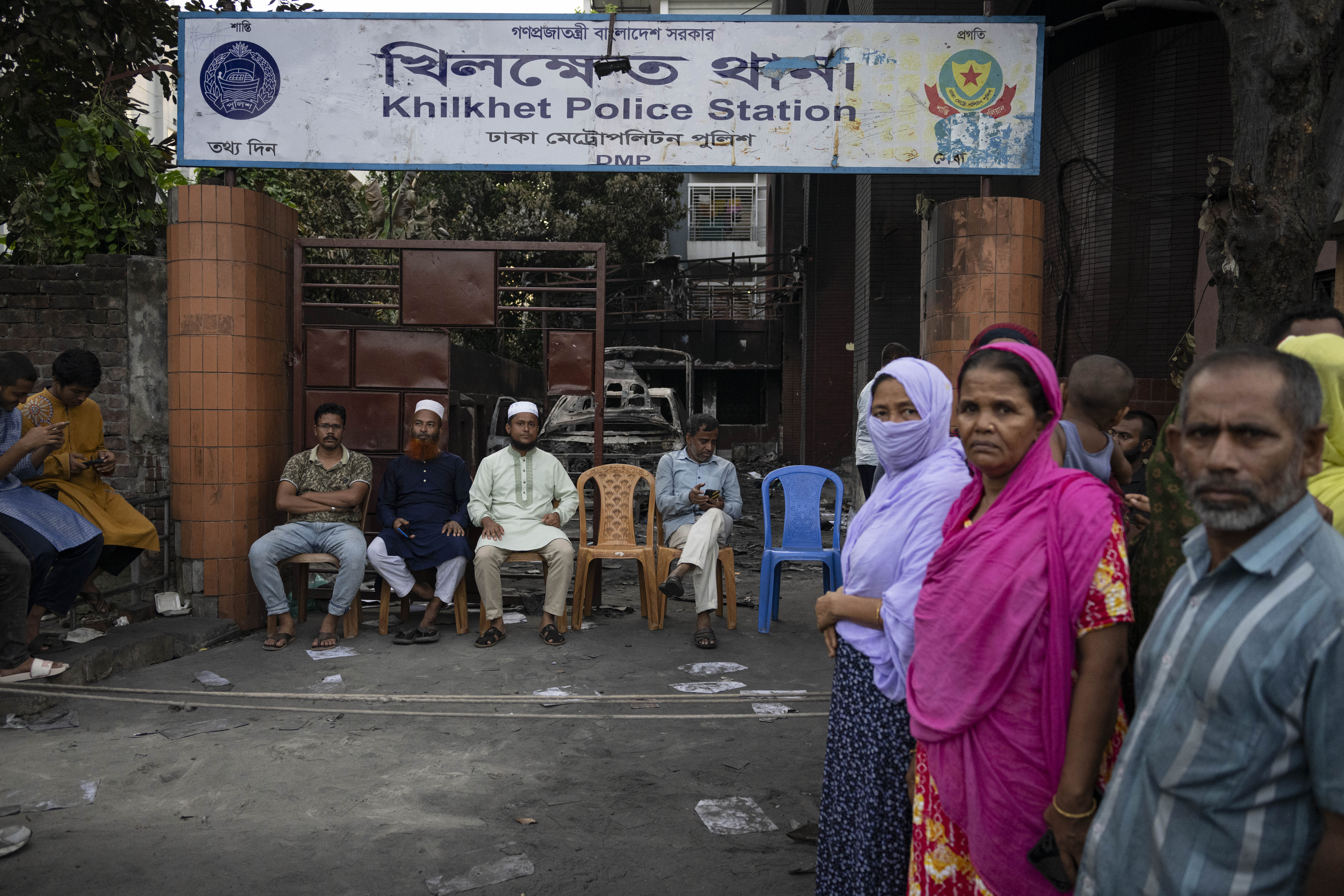 Vakter utanför en delvis sönderslagen polisstation efter kravallerna i Bangladeshs huvudstad Dhaka. Foto: Fatima Tuj Johora/AP/TT