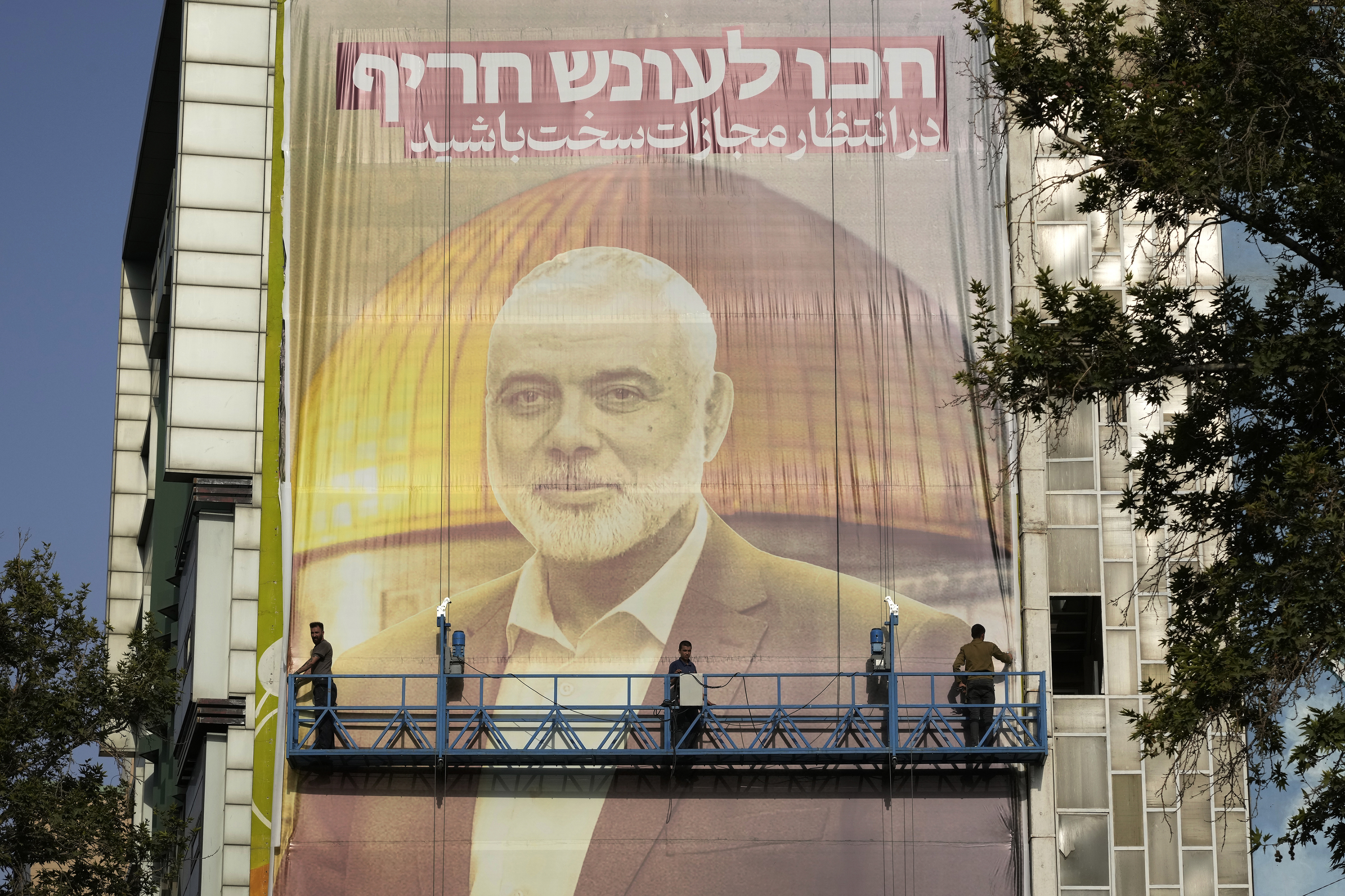 Dödade Hamasledaren Ismail Haniya pryder en stor banderoll i Irans huvudstad Teheran med budskapet: Räkna med ett hårt straff. Arkivbild. Foto: Vahid Salemi/AP/TT