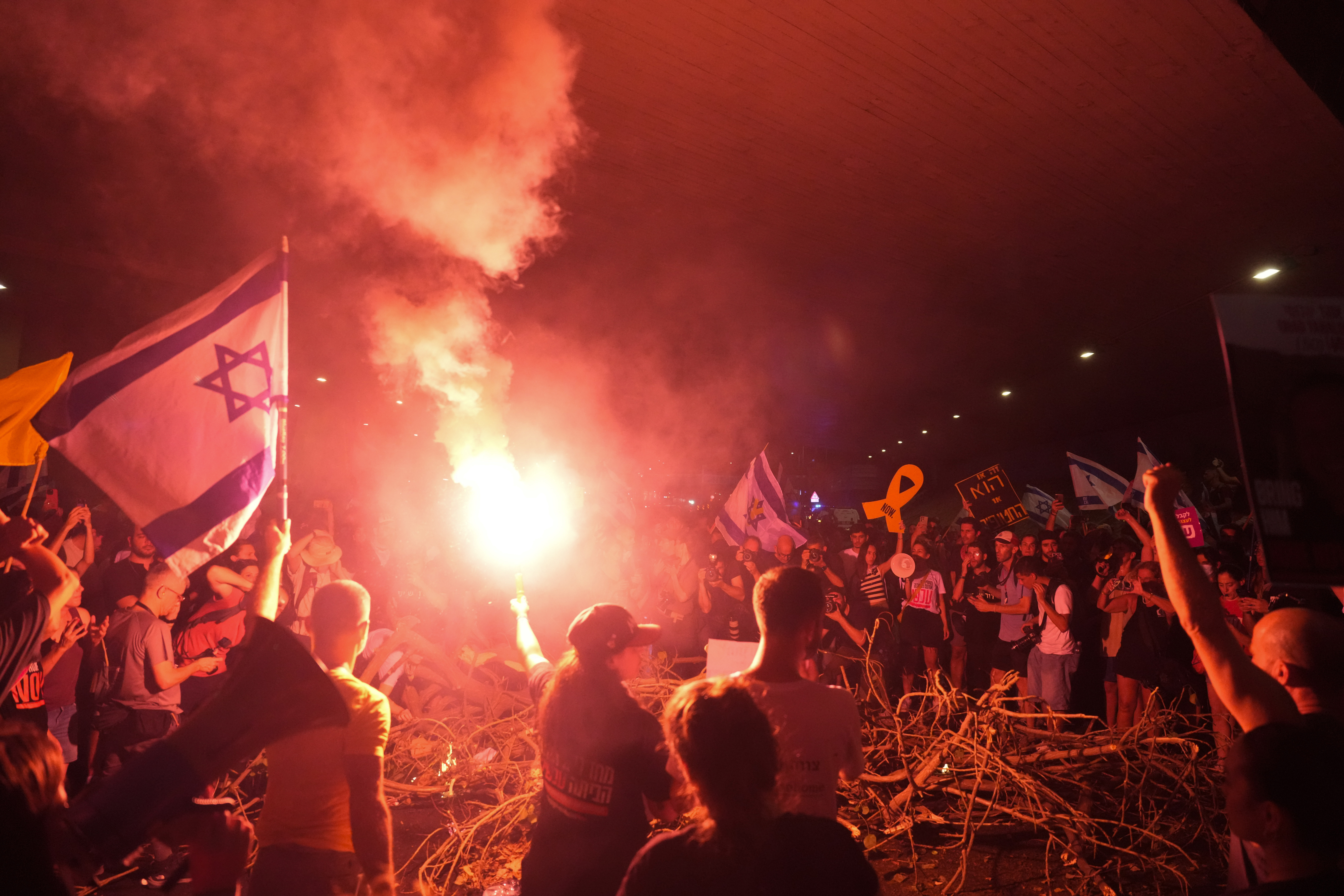 Demonstranter blockerar en väg i Tel Aviv på söndagskvällen. Foto: Ariel Schalit/AP/TT