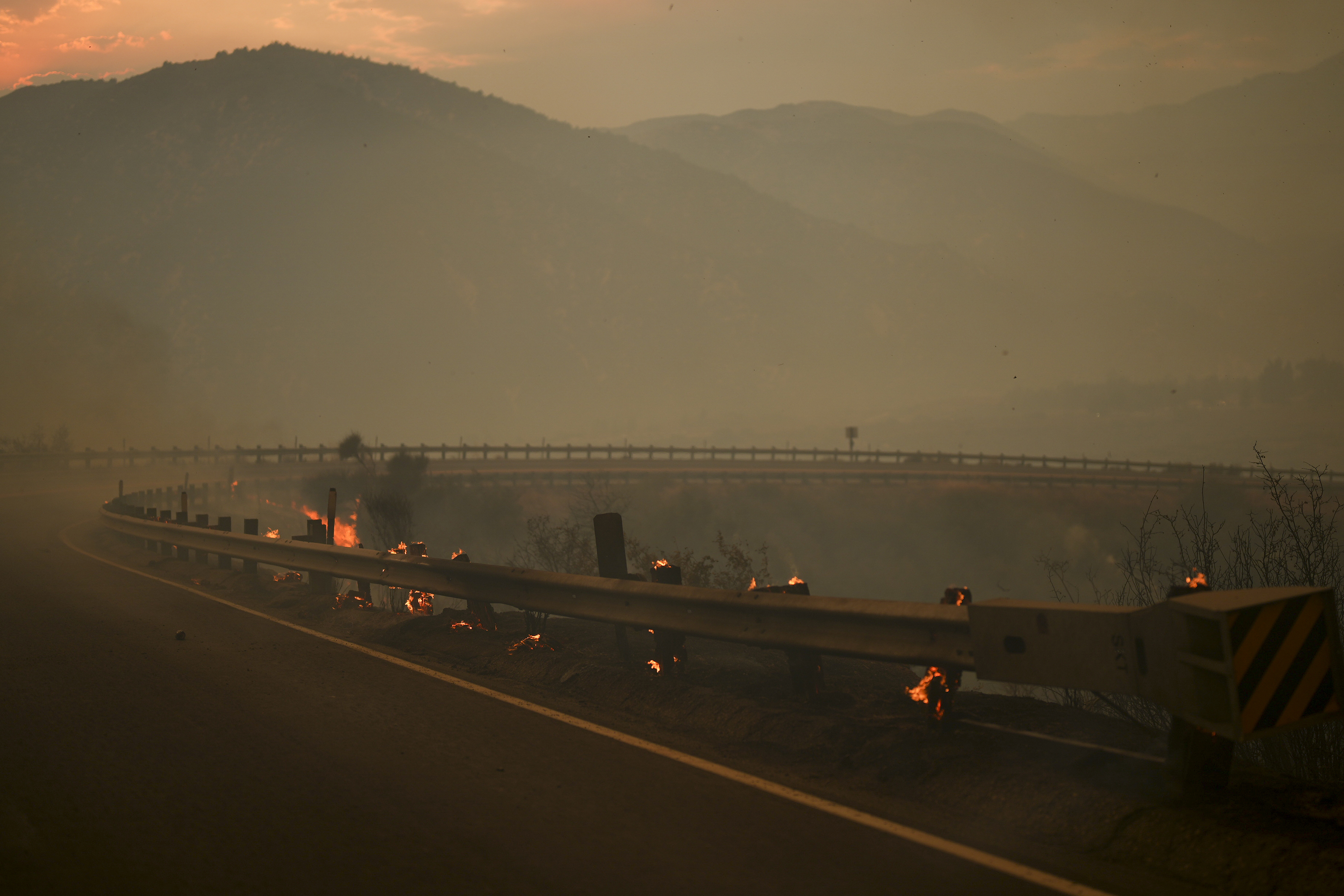 En tjock dimma av brandrök syns i området där storbranden härjar utanför Los Angeles. Bild från lördagen. Foto: Eric Thayer/AP/TT