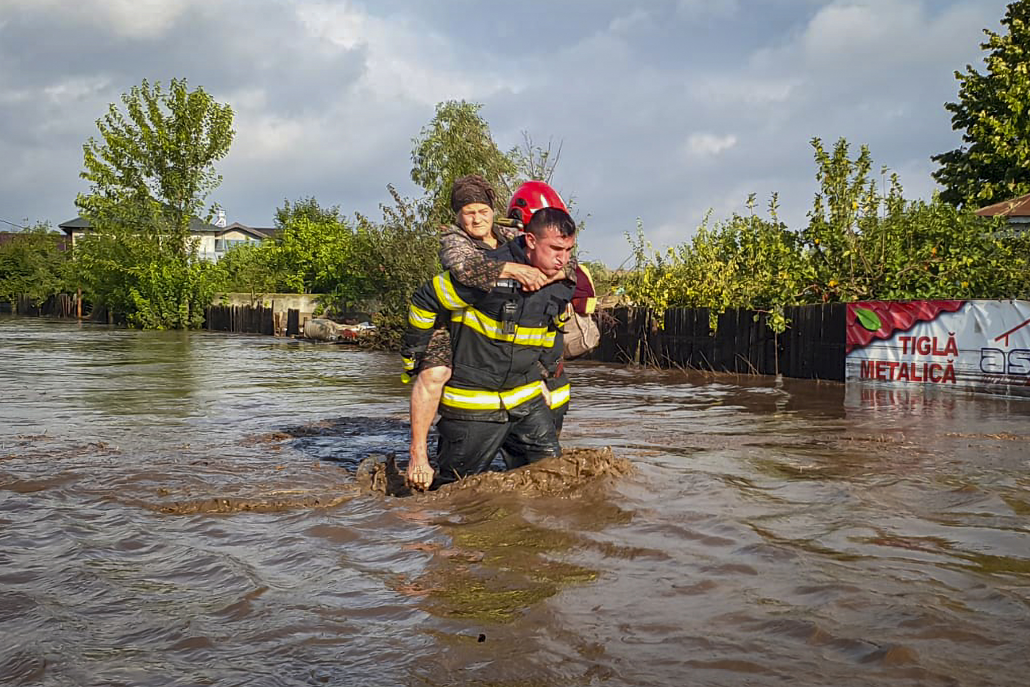 En räddningsarbetare hjälper en kvinna i Rumänien. Foto: Rumänska räddningsmyndigheten/AP/TT