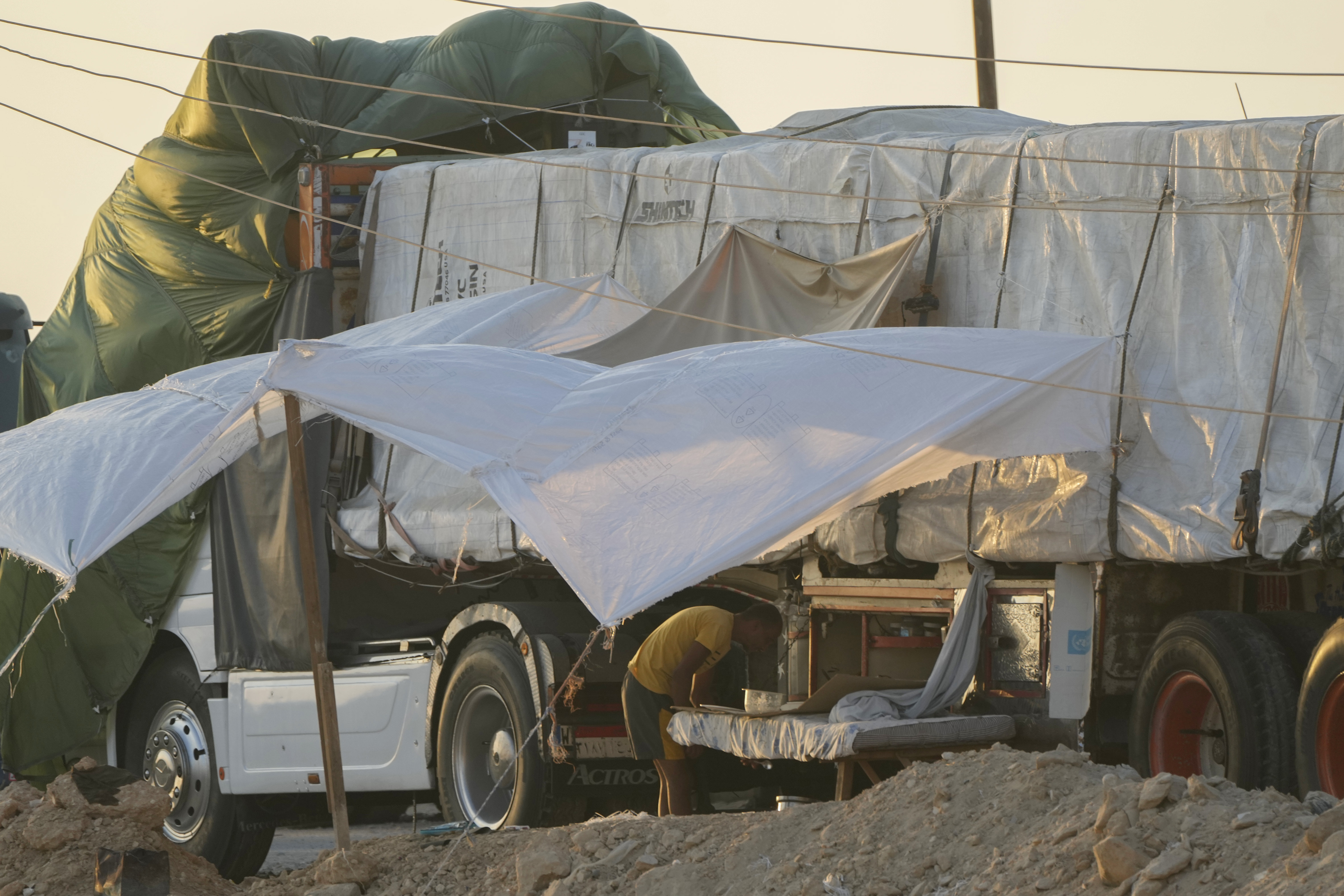 En av de egyptiska chaufförerna har byggt sig ett litet läger på sidan av sin Mercedes-lastbil nära Rafah-övergången. Bild från i början av september. Foto: Amr Nabil/AP/TT